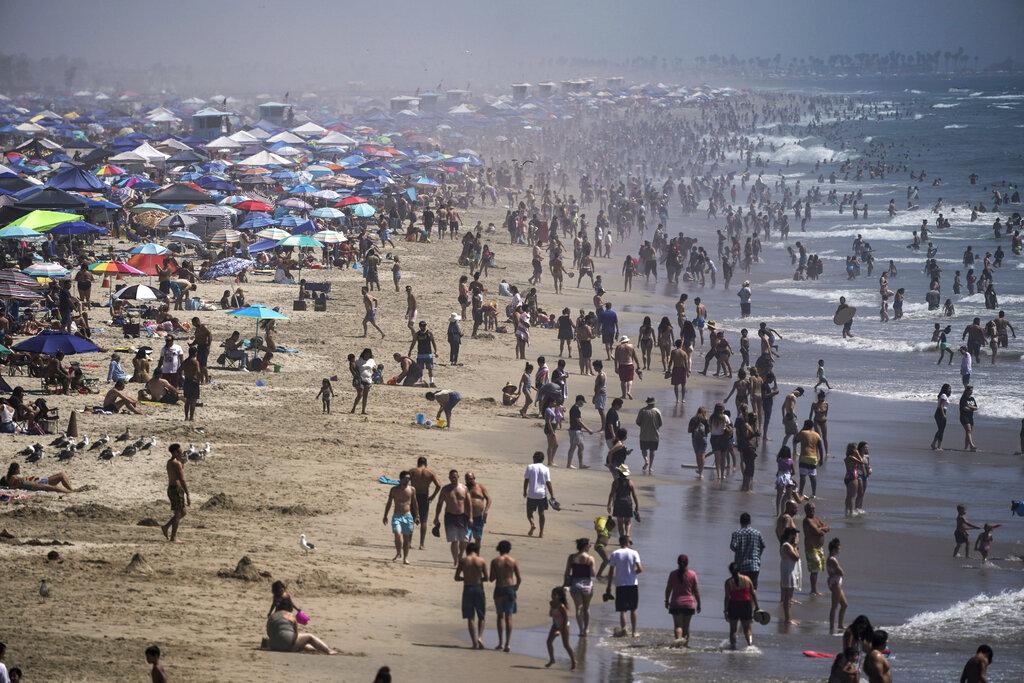 In this Saturday, Sept. 5, 2020 file photo, people crowd the beach in Huntington Beach, Calif., as the state swelters under a heat wave. (AP Photo / Jae C. Hong)