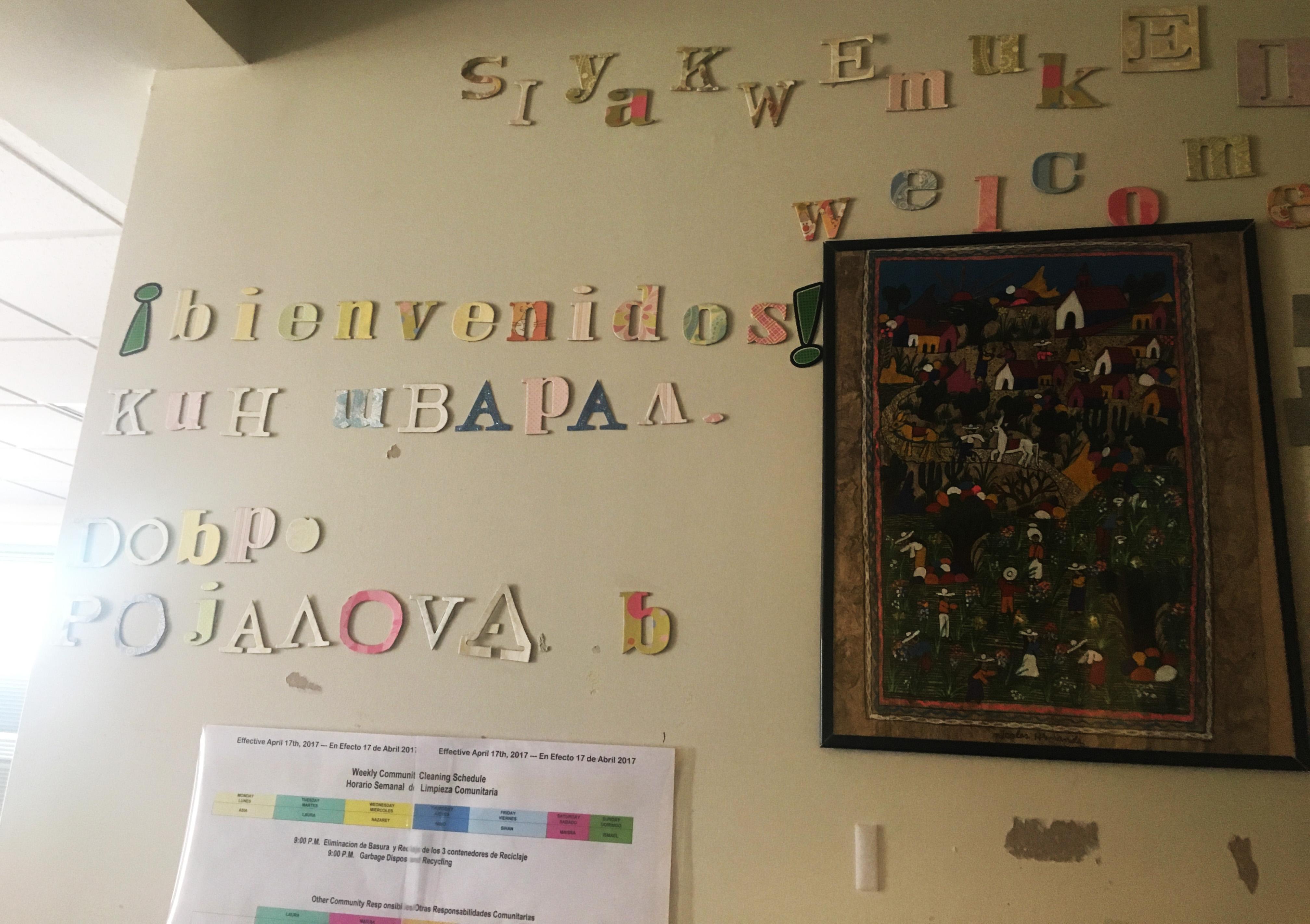 "Welcome" is written in a variety of languages in the entrance to the dining room and kitchen area, where a chore chart also hangs. (Maya Miller / Chicago Tonight