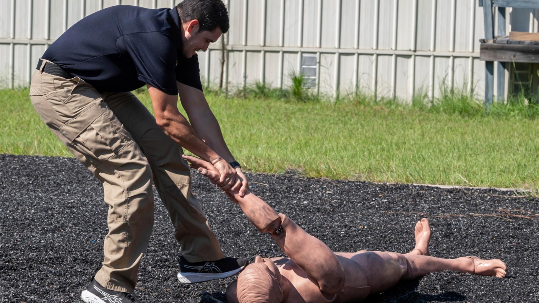 An Immigration and Customs Enforcement (ICE) instructor demonstrates getting a 170 lb. dummy into a position to be handcuffed on the agility course at the Federal Law Enforcement Training Centers (FLETC) in Brunswick, Ga. on Thursday, Aug. 21, 2025. (AP Photo / Fran Ruchalski)