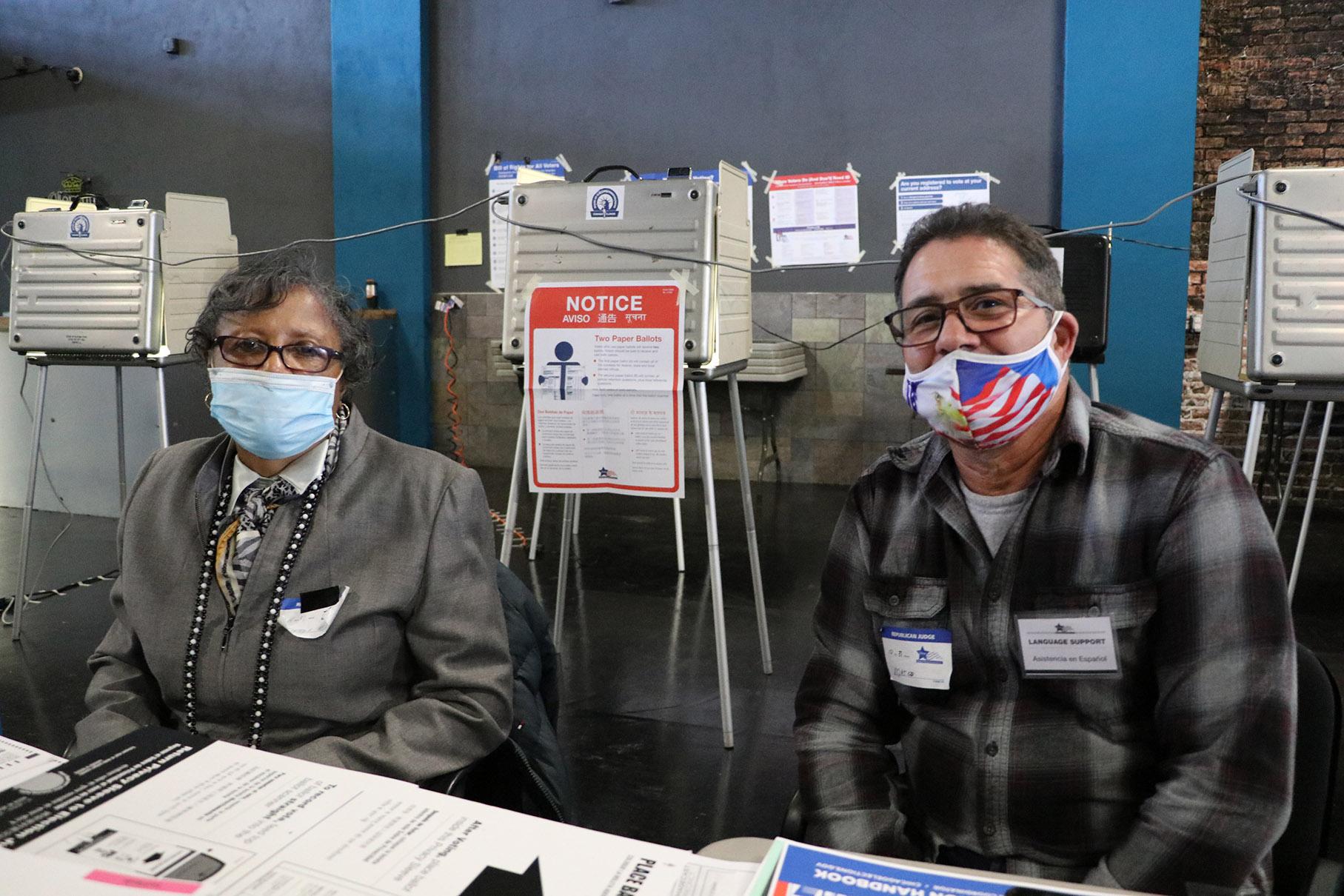 Poll workers Janice Meeks and Marco Rivera at El Mexico Moderno Ballroom in West Humboldt Park. By noon on Election Day, more than 170 ballots had been cast in their precinct. “The numbers — we usually have about 900 to 1,000 on an election year like this, so we’re just waiting to see the numbers,” Rivera said. (Evan Garcia / WTTW News)