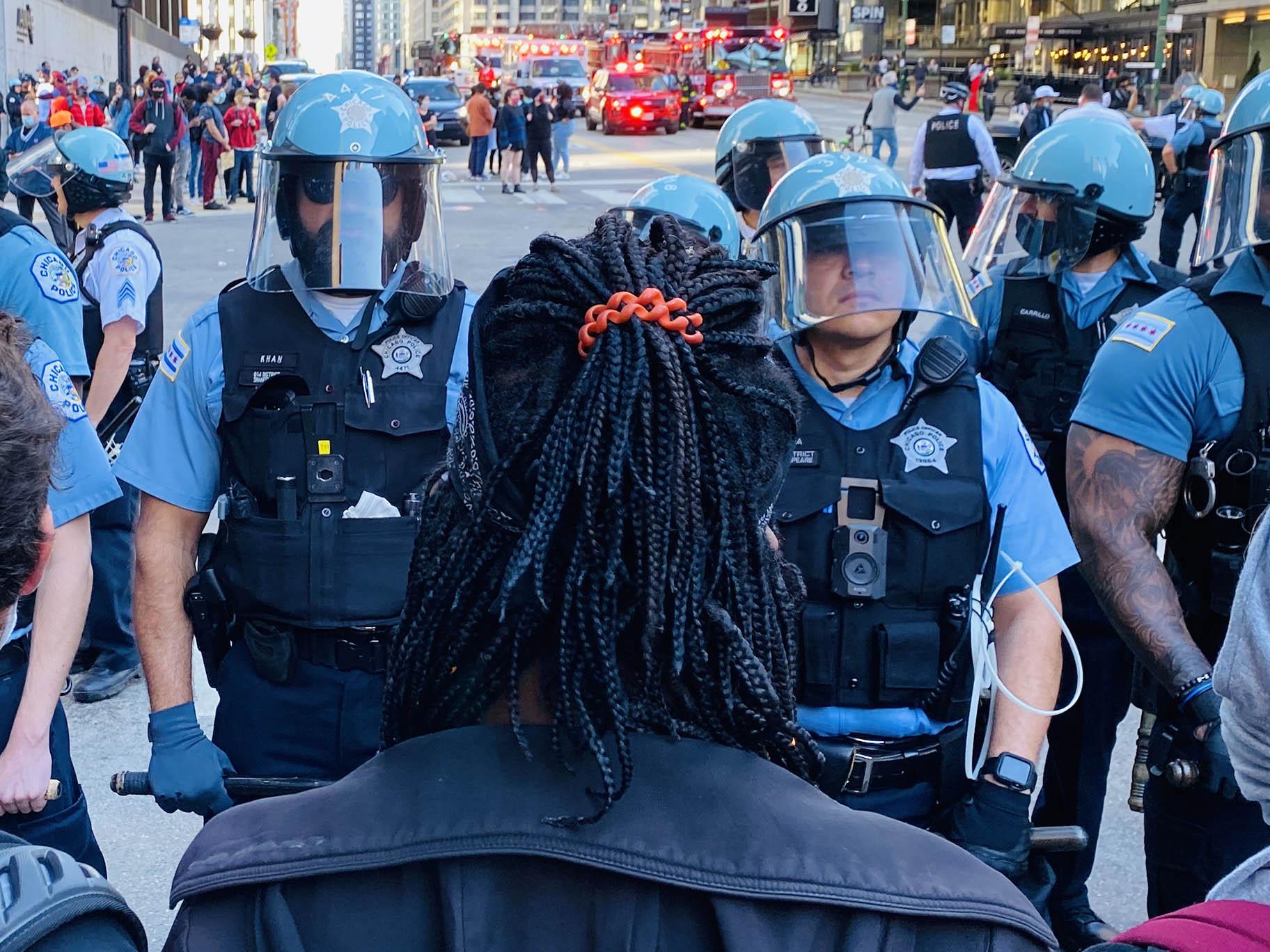 A protester faces a line of police officers in Chicago on Saturday, May 30, 2020. (Hugo Balta / WTTW News)