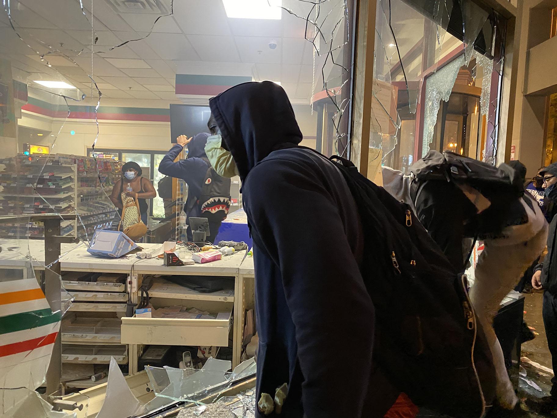 Protests on Saturday turned violent as some looters smashed store windows and stole merchandise. (Hugo Balta / WTTW News)