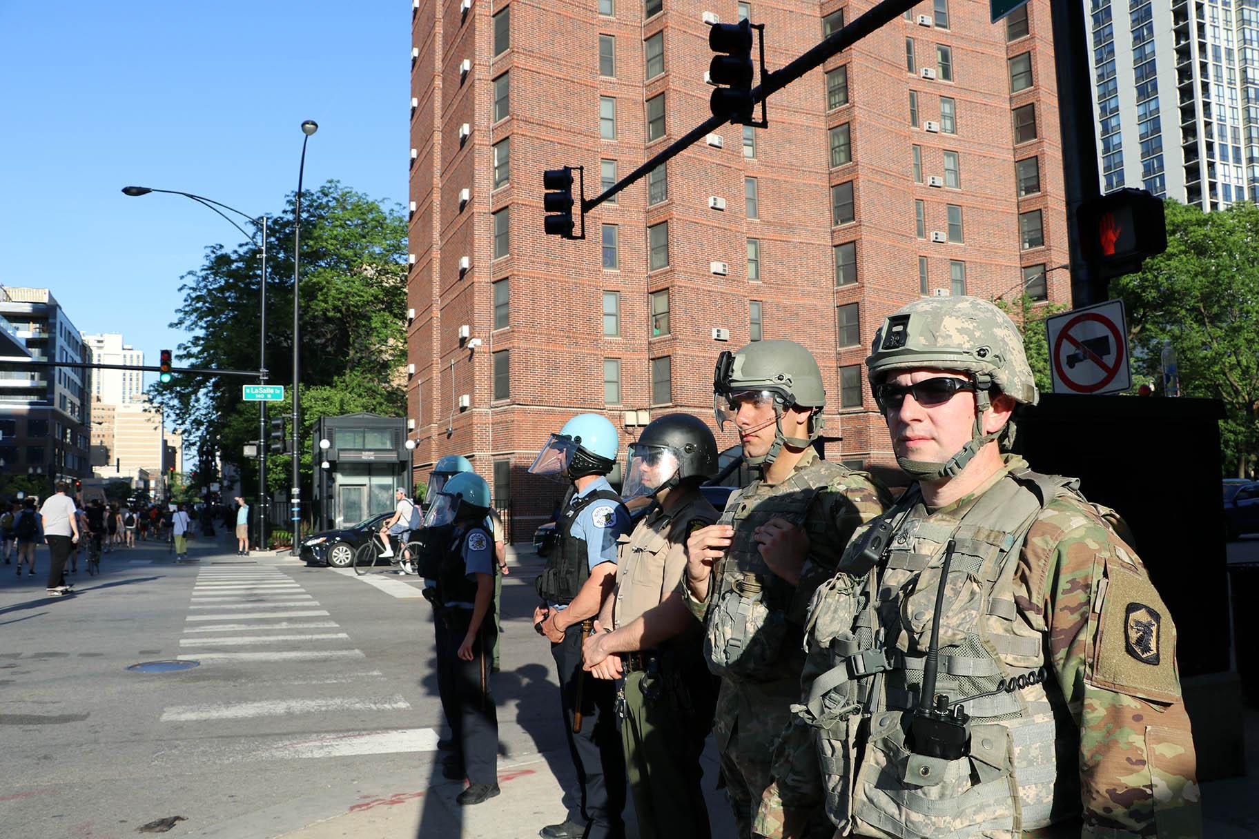 Illinois National Guard officers watch a protest in Old Town on June 6, 2020, one of many in the city and across the U.S. sparked by the death of George Floyd while in Minneapolis police custody. (Evan Garcia / WTTW News)