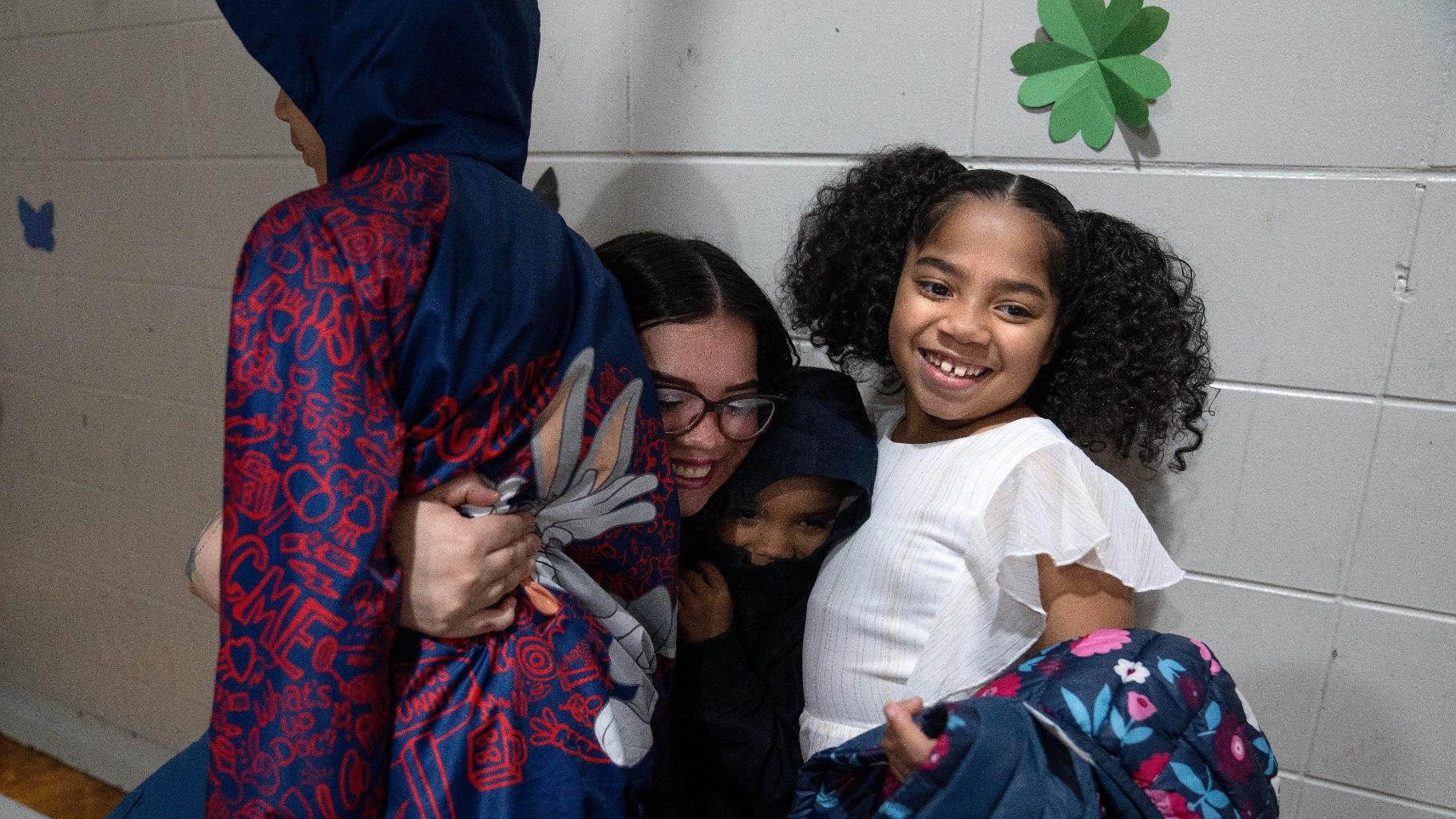 Crystal Martinez hugs three of her five children, from left, Reggie Johnson, 10, Jayceon Santiago, 5, and Myla Martinez, 6, during a special visit at Logan Correctional Center, Saturday, May 20, 2023, in Lincoln, Ill. (AP Photo / Erin Hooley)