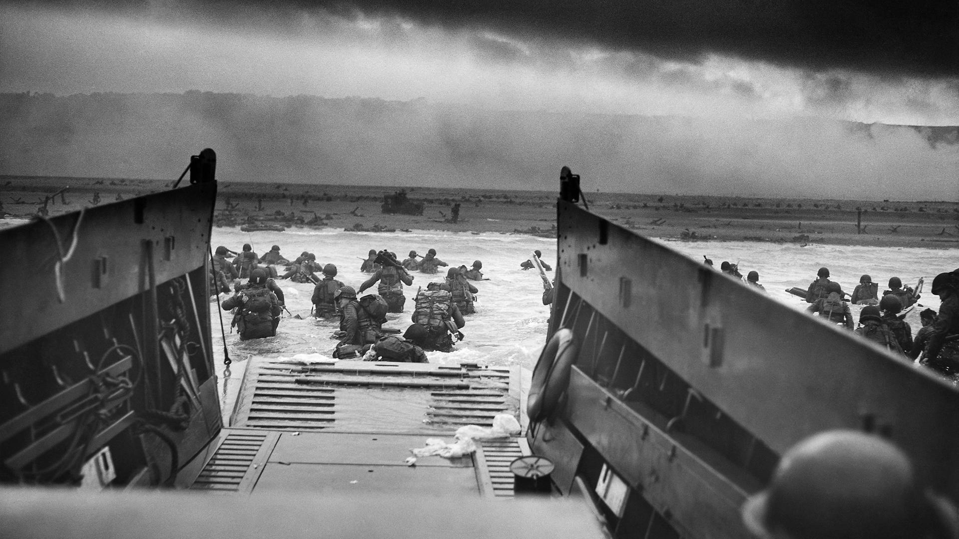 A landing craft, vehicle and personnel from the U.S. Coast Guard-manned USS Samuel Chase disembarks troops of Company E, 16th Infantry, 1st Infantry Division (the Big Red One) wading onto the Fox Green section of Omaha Beach on the morning of June 6, 1944. (Photo by Chief Photographer's Mate Robert F. Sargent / Wikimedia Commons)