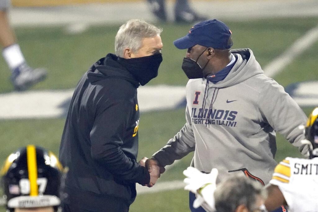 Iowa head coach Kirk Ferentz, left, and Illinois head coach Lovie Smith shakes hands after an NCAA college football game Saturday, Dec. 5, 2020, in Champaign, Ill. Iowa won 35-21. (AP Photo / Charles Rex Arbogast)