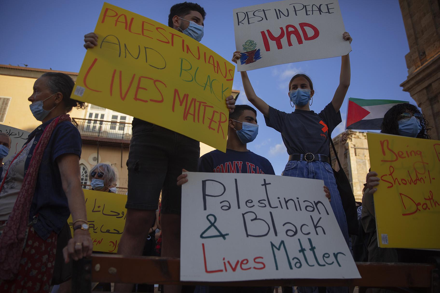 Protesters hold signs during a demonstration against the Israeli police after border police officers shot and killed Iyad al-Halak, an unarmed autistic Palestinian man, in the mixed Arab Jewish city of Jaffa, near Tel Aviv, Israel, after saying they suspected he was carrying a weapon, Sunday, May 31, 2020. Protesters gathered to protest the killing of al-Halak in Jerusalem and the killing of George Floyd in Minneapolis last week. (AP Photo / Oded Balilty)