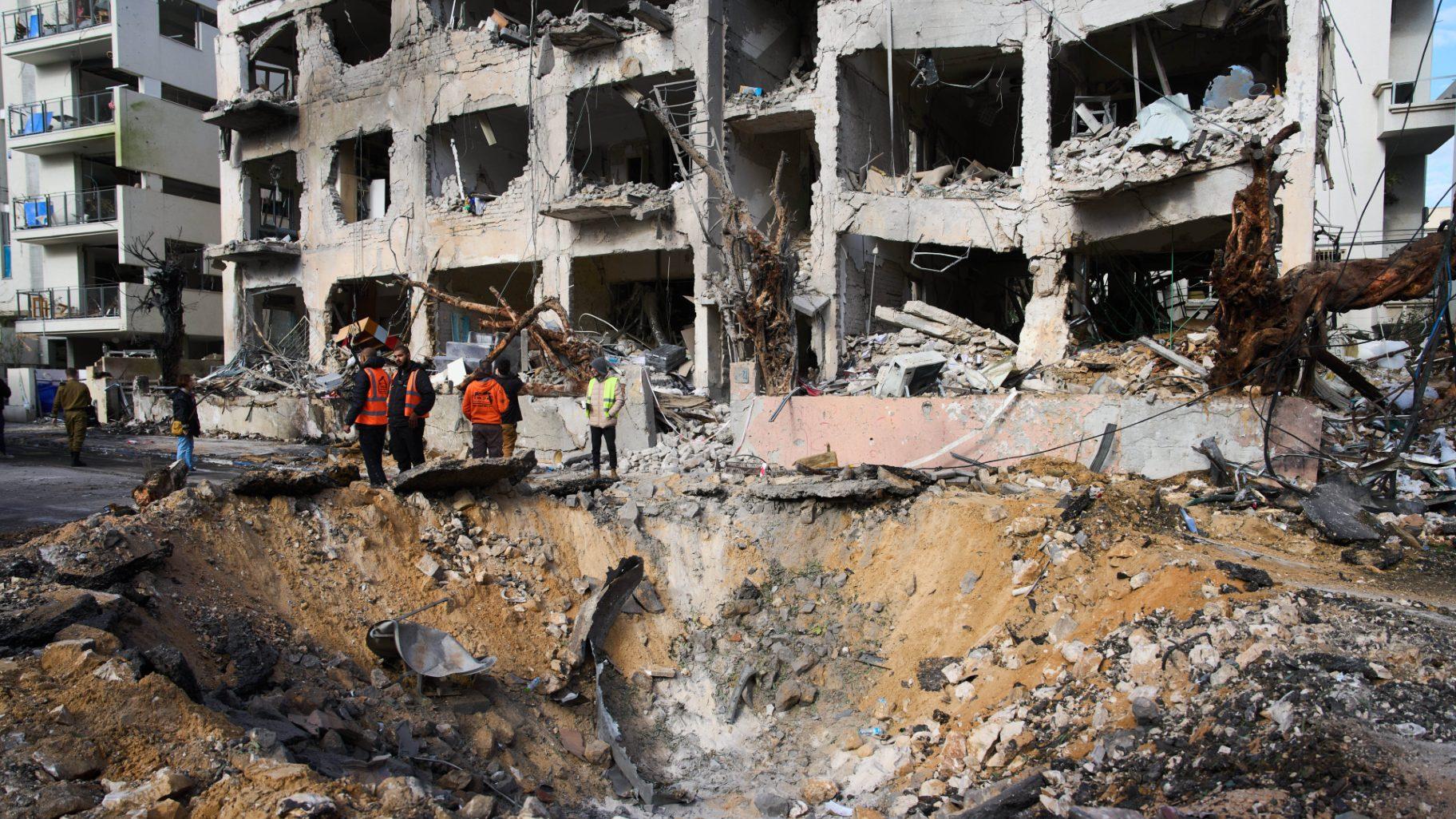 Rescue workers and military personnel survey the scene of a direct hit a day after an Iranian missile struck in Tel Aviv, Israel, Sunday, March 1, 2026. (AP Photo / Oded Balilty)