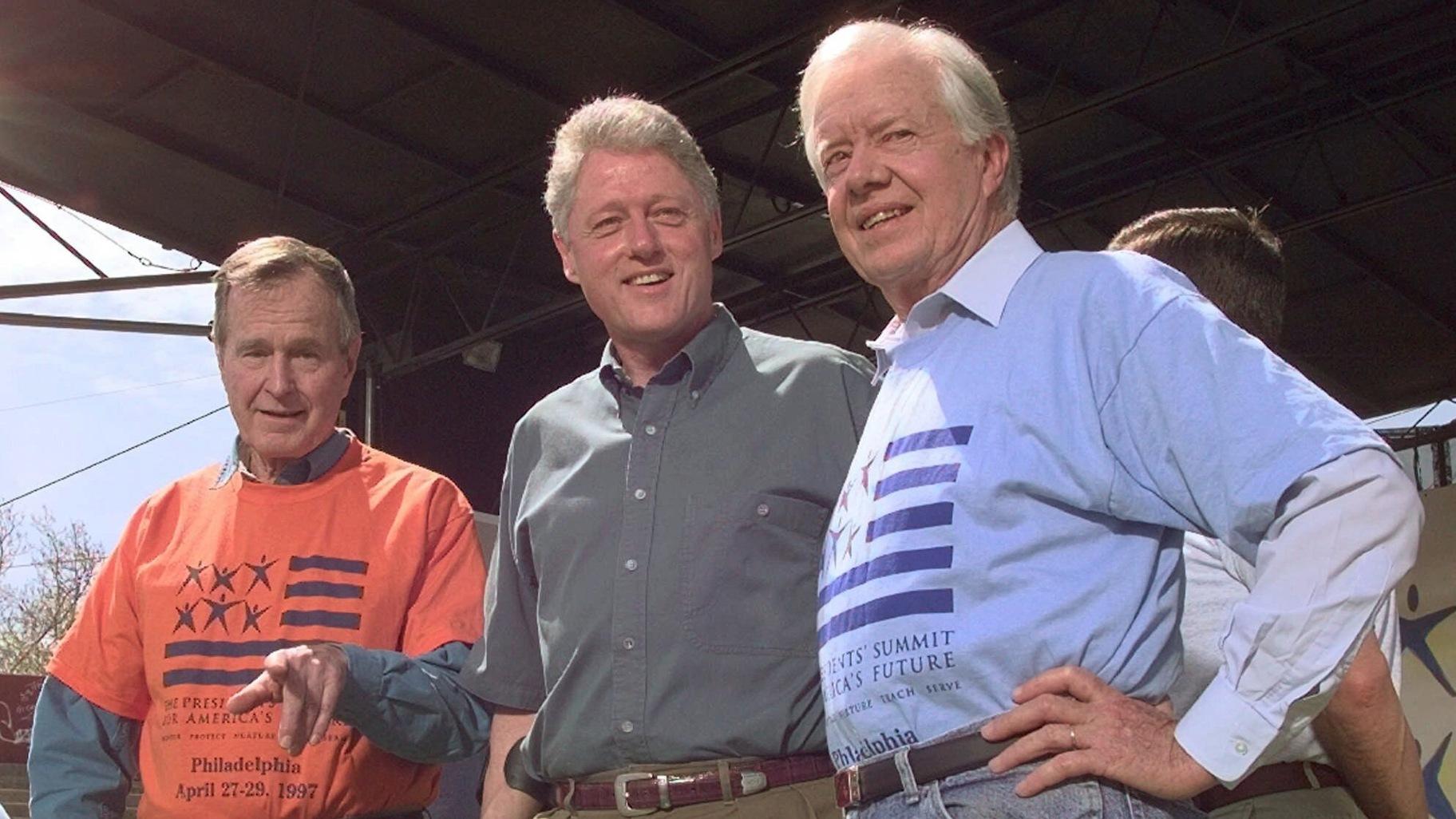 FILE - Former Presidents George Bush, left, and Jimmy Carter, right, stand with President Clinton during a kick-off rally for the President's volunteer summit at Marcus Foster Stadium in Philadelphia, PA., April 27, 1997. (Greg Gibson / AP Photo, File)