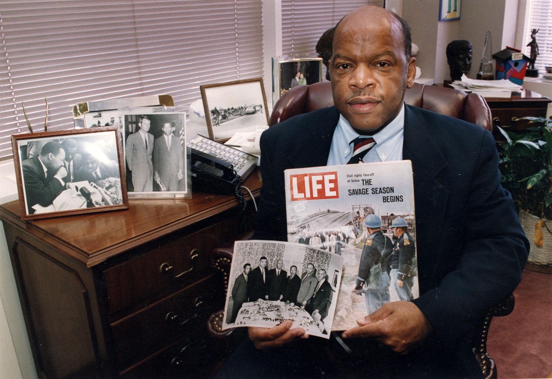 Congressman John Lewis is seen in his Atlanta office with two of his favorite items from his collection of memorabilia from his younger days as a civil rights activist in the 1960s. (Atlanta Journal-Constitution via AP)