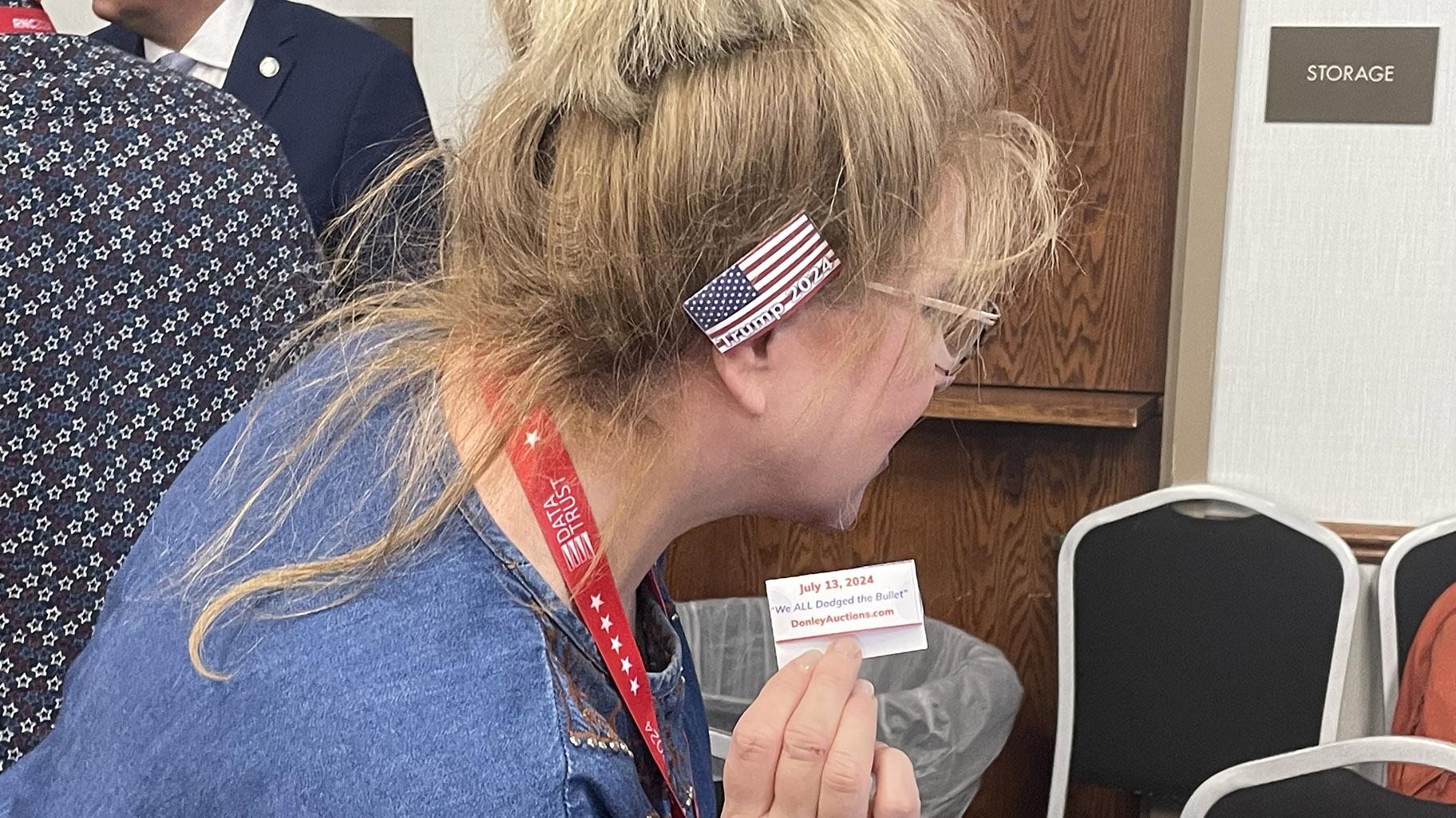 Karen Tirio, an Illinois delegate to the RNC from McHenry, shows off an ear bandage designed to look like the one worn by Republican nominee Donald Trump after an assassination attempt on July 18, 2024. (Heather Cherone/WTTW News)