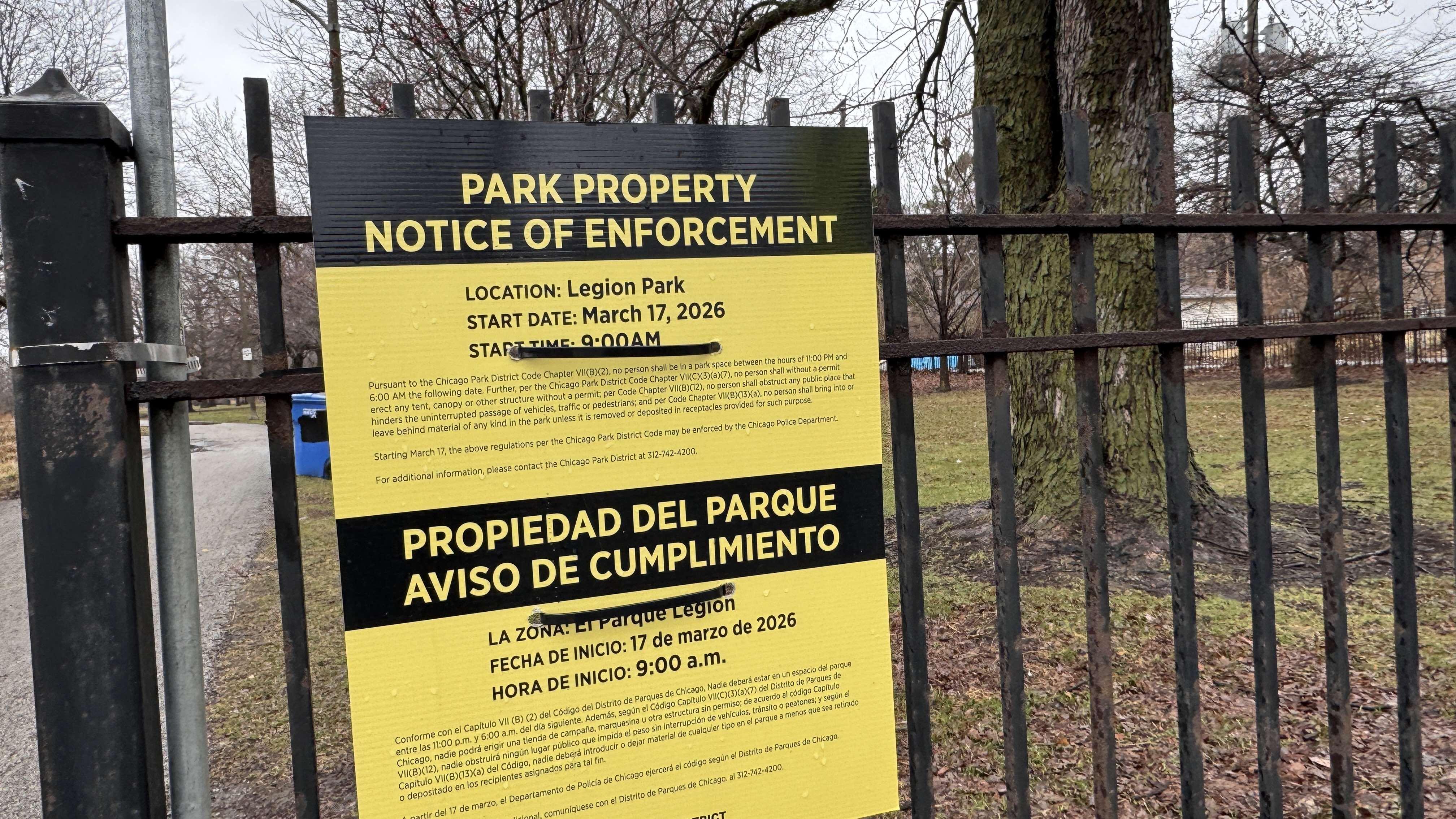 Signs posted in Legion Park announce the Park District’s intention to enforce restrictions against camping, as of March 17. Advocates for the unhoused are demanding that a tent encampment in the park be allowed to remain. (Patty Wetli / WTTW News)