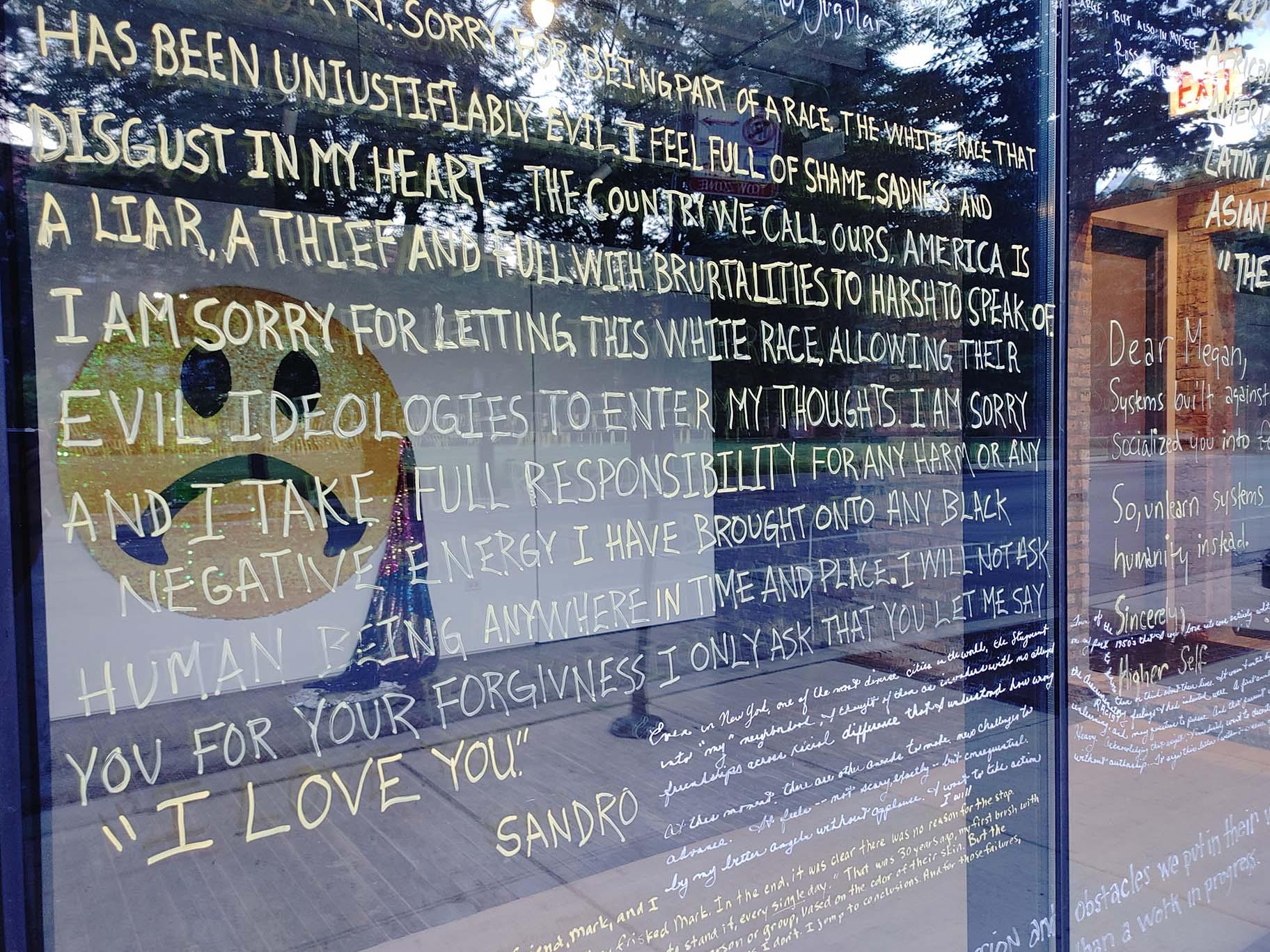 The completed installation “Letters to the World” on the windows of Facility on Sunday, July 12, 2020. (Erica Gunderson / WTTW News)
