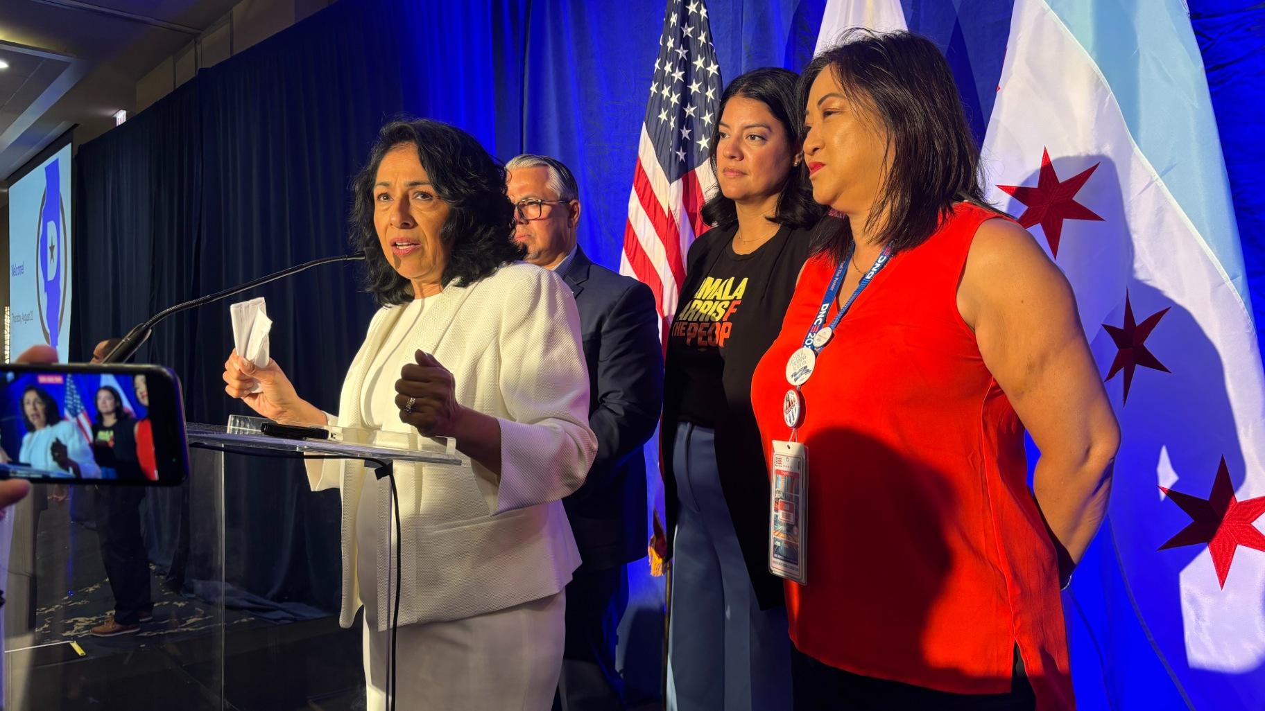 State Rep. Lisa Hernandez, chair of the Illinois Democratic Party, fields questions from the news media while dressed in white, a nod to the suffragette movement that led to the passage of the 19th Amendment, in honor of Vice President Kamala Harris’ acceptance speech set to take place later Thursday. (Heather Cherone / WTTW News)