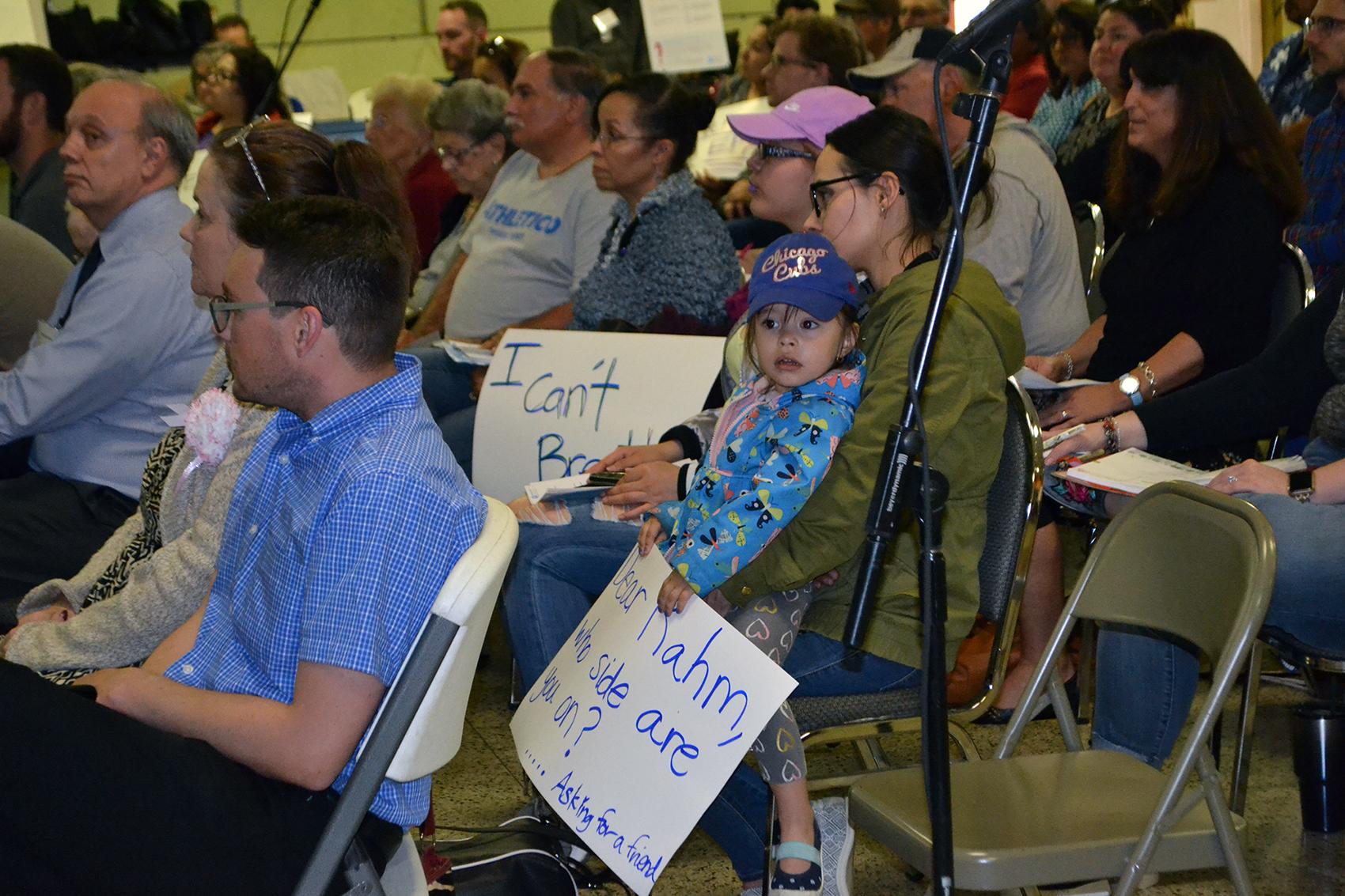 Liliana Flores sits with her young daugther at a public meeting Thursday night to address concerns about residents' exposure to manganese on the Southeast Side. (Alex Ruppenthal / Chicago Tonight) 