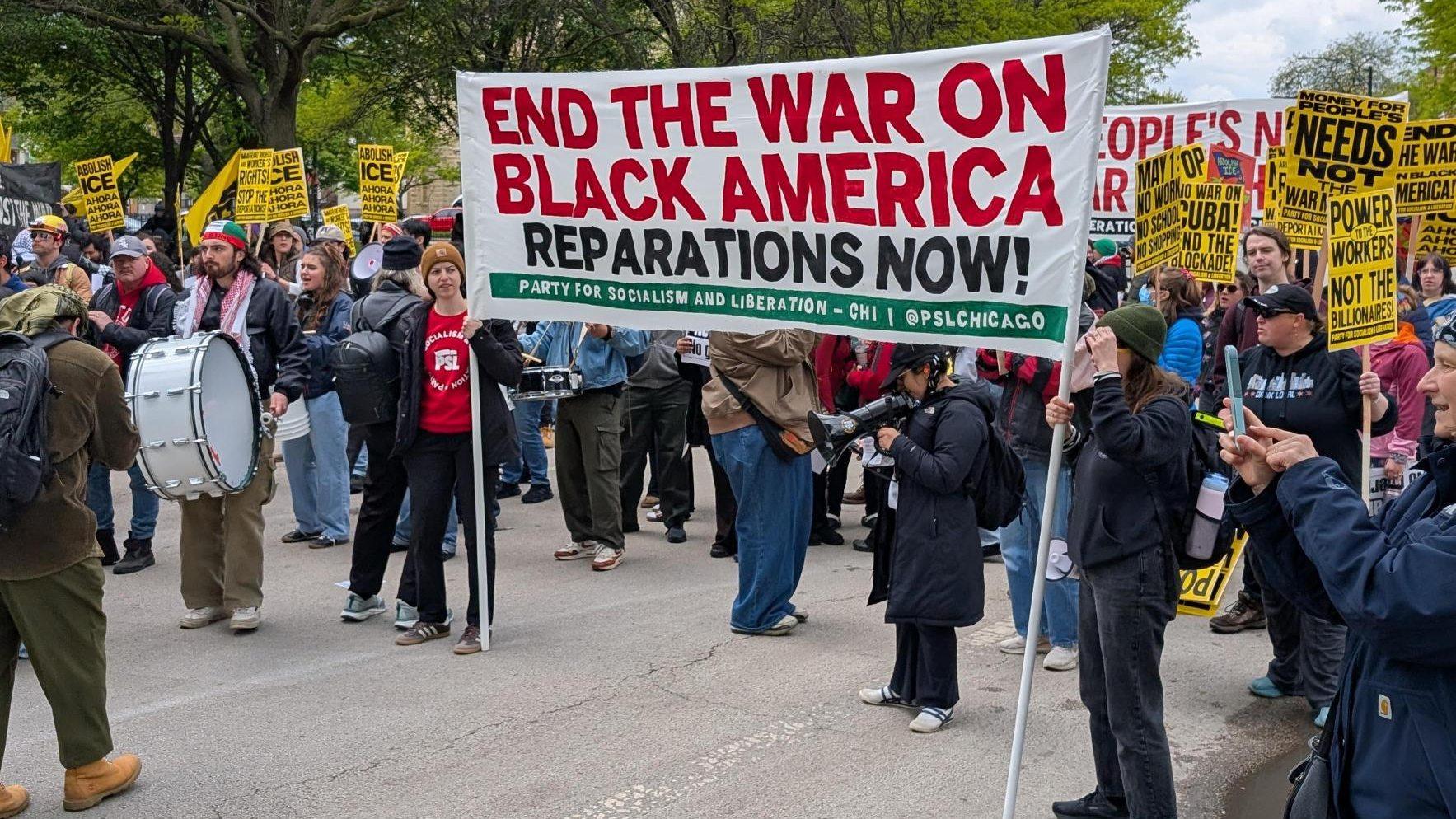 Demonstrators carry signs at the Union Park May Day rally on May 1, 2026. (Matt Masterson / WTTW News)