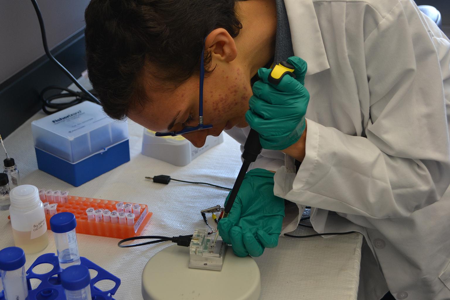 UIC bioengineering graduate student Elena Boselli applies a solution containing manganese to a sensor that detects levels of toxic metals in blood. (Alex Ruppenthal / Chicago Tonight)