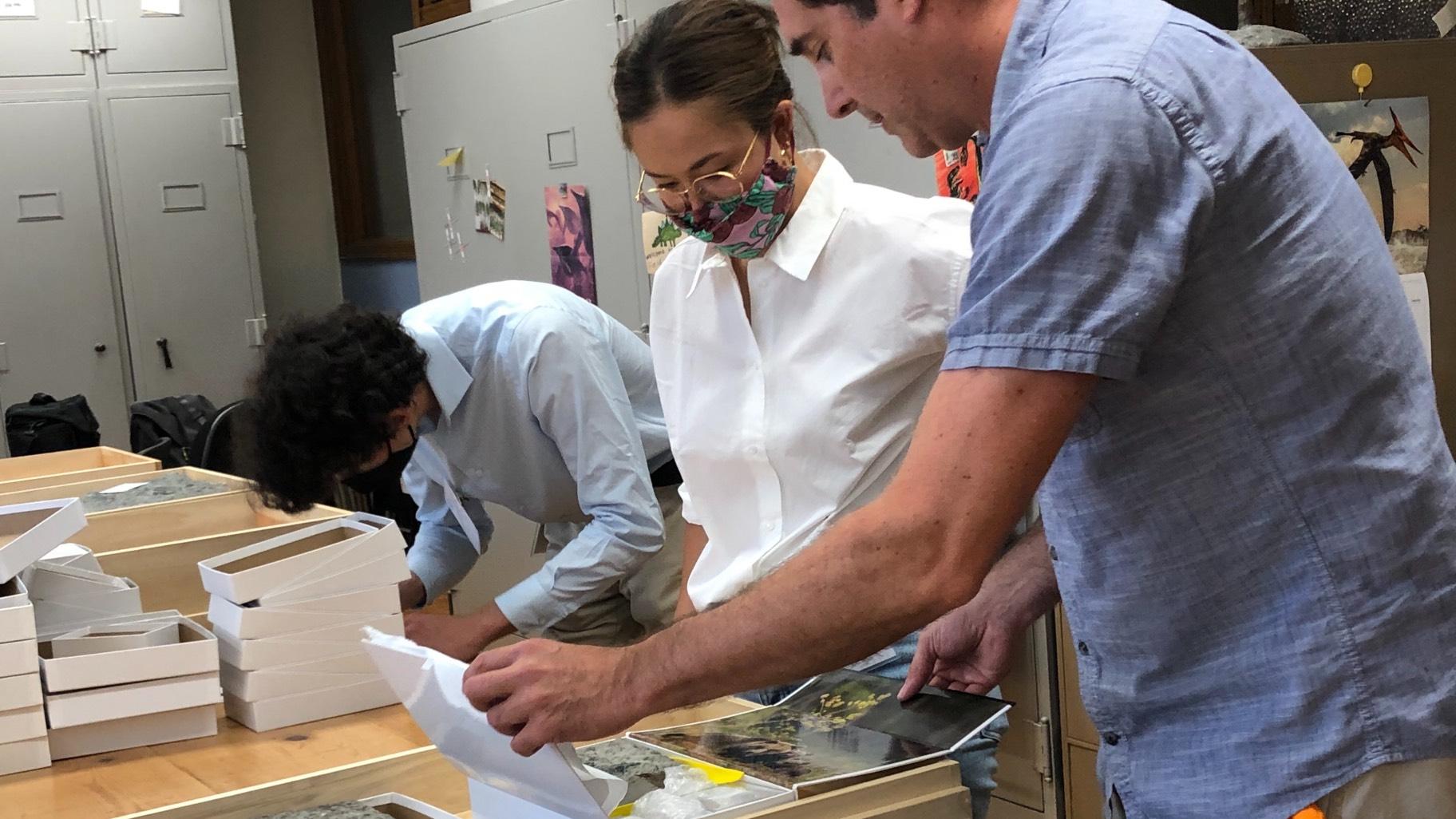 Unboxing day at the Field Musem. Postdoctoral fellow Maria Valdes (l) and Jim Holstein, collection manager of meteoritics and physical geology, unwrap newly arrived fossilized meteorites. (Patty Wetli / WTTW News)