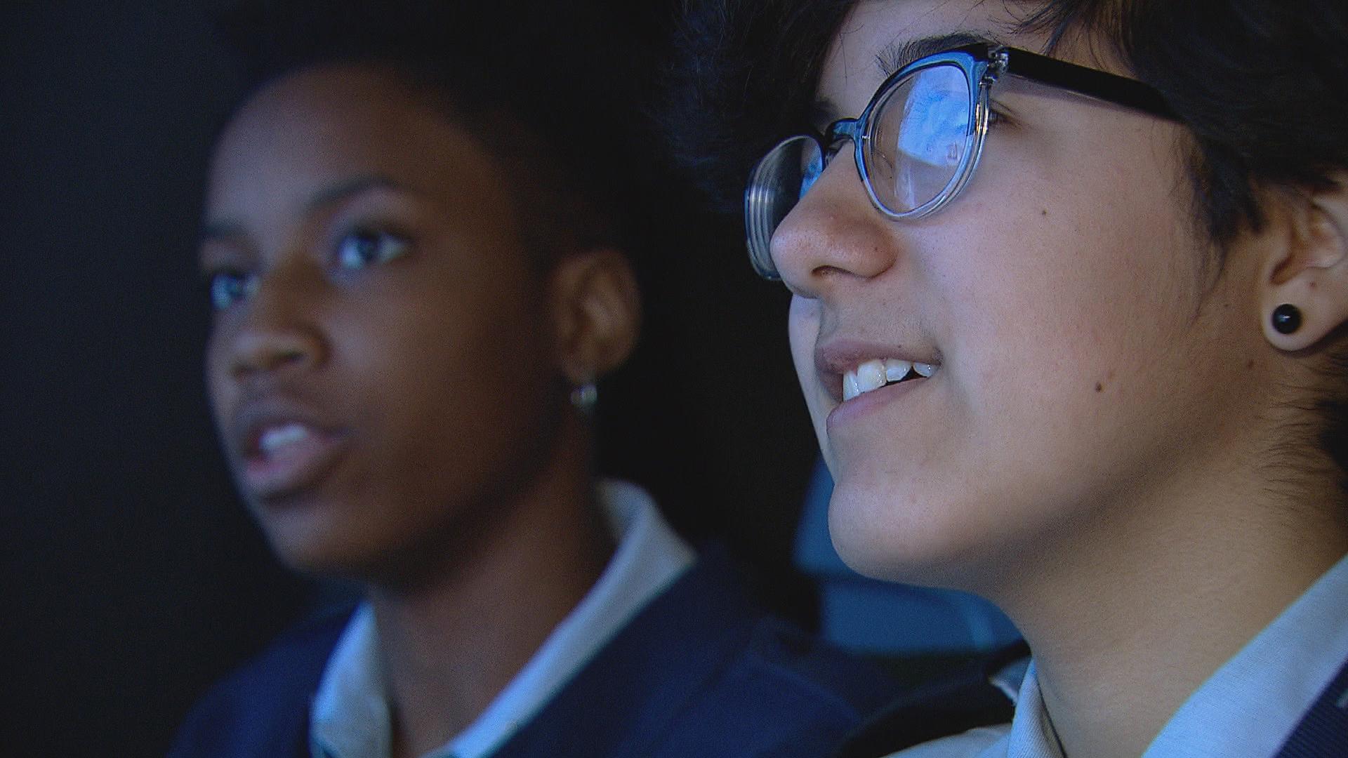 Students Tori Neealy, left, and Leah Nunez in a flight simulator at Air Force Academy High School.