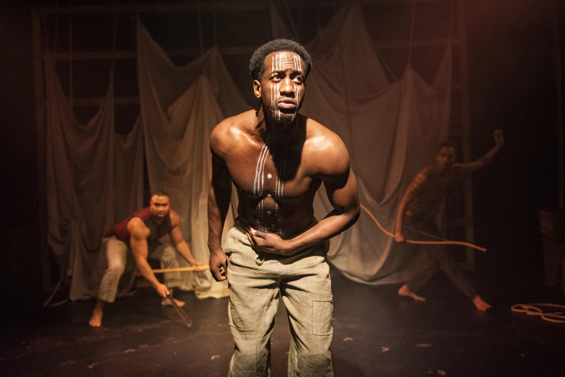 David Goodloe, center, with Lewon Johns, back left, and Michael Turrentine in Griffin Theatre Company’s Midwest premiere of “Mlima’s Tale.” (Photo by Michael Brosilow)