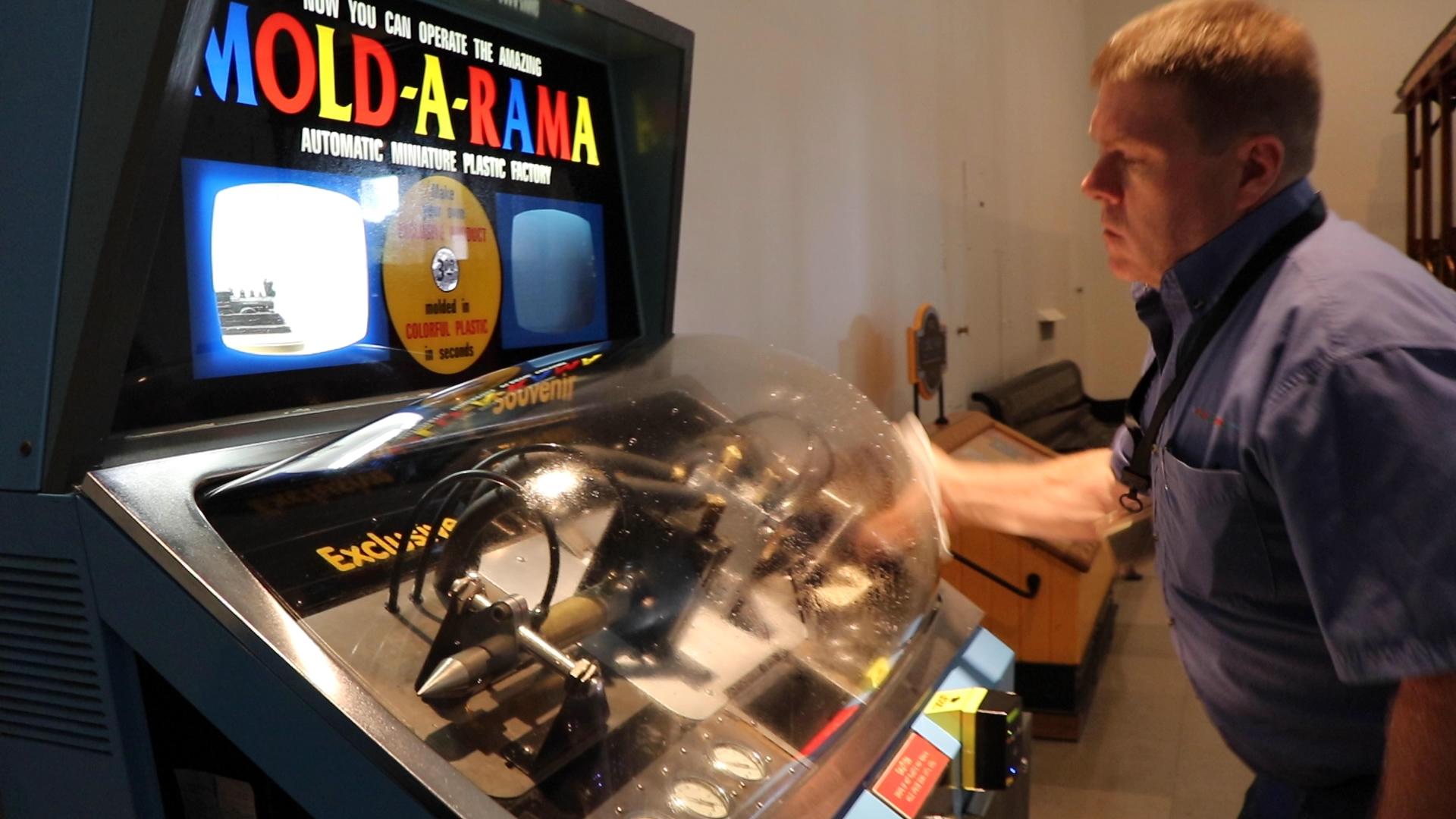 Mold-A-Rama Inc.のポール・ジョーンズ氏は、科学産業博物館でお土産用マシンをチェックしています。 (Evan Garcia / WTTW News)