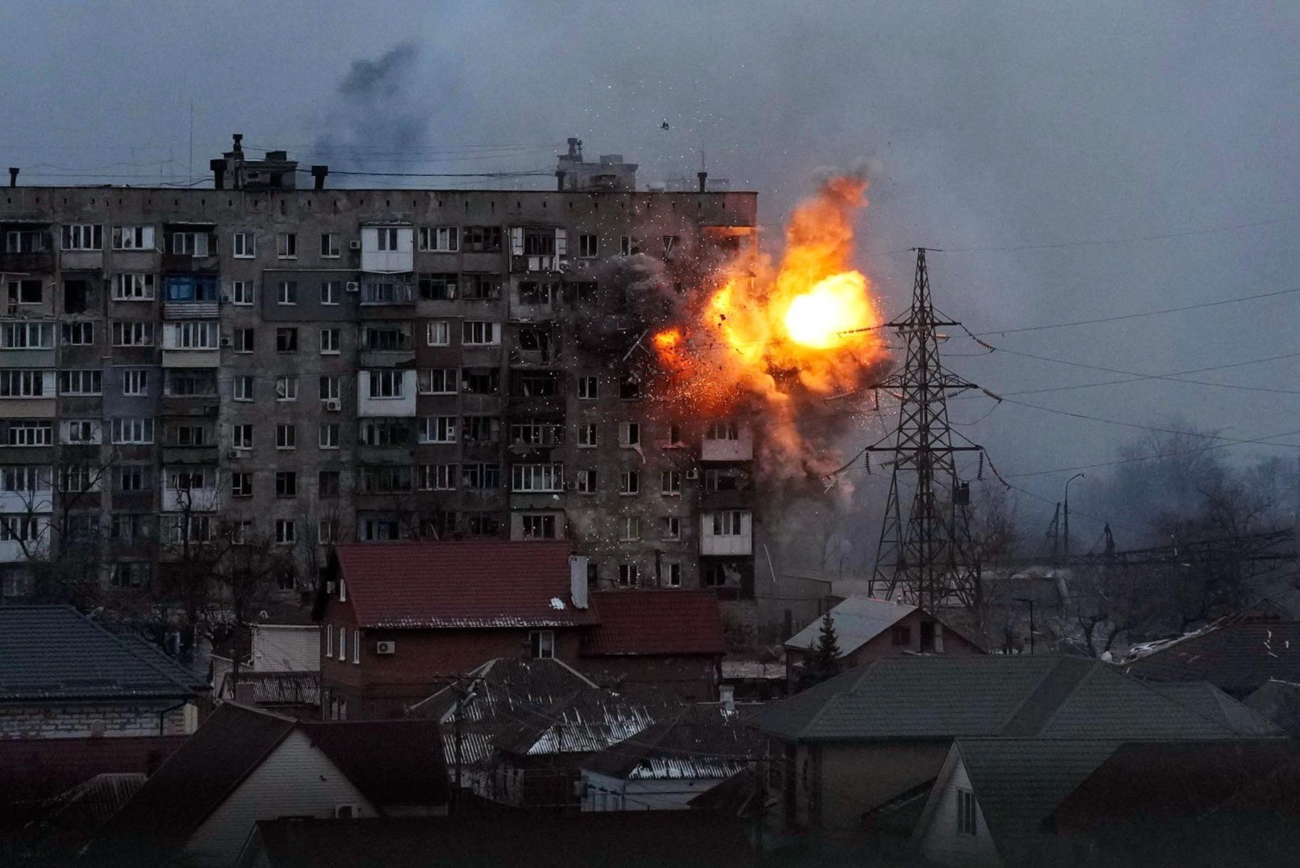 An explosion is seen in an apartment building after a Russian army tank fires in Mariupol, Ukraine, March 11, 2022. Still from FRONTLINE PBS and AP’s feature film “20 Days in Mariupol.” (AP Photo / Evgeniy Maloletka)
