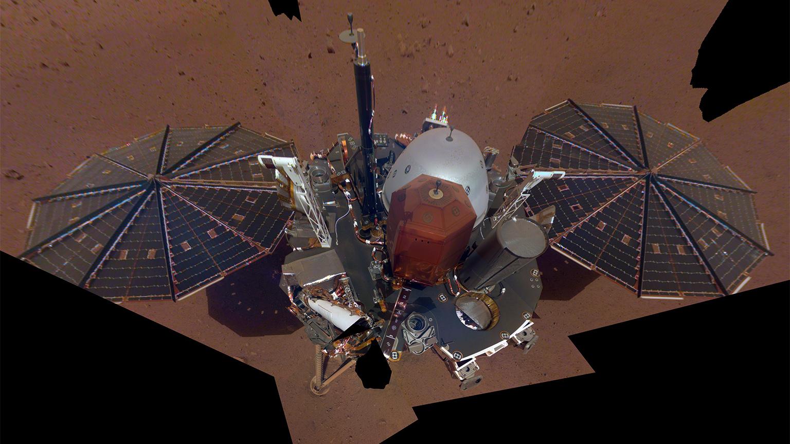 NASA InSight’s first full “selfie” on Mars, taken Dec. 6, 2018, displays the lander’s solar panels and deck. On top of the deck are its science instruments, weather sensor booms and UHF antenna. (Credit: NASA / JPL-Caltech)