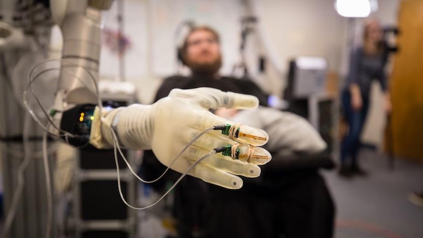 Nathan Copeland, who was paralyzed from the chest down in a car accident, controls a prosthetic arm and hand at the University of Pittsburgh Medical Center. (Photo courtesy of Pitt / UPMC)