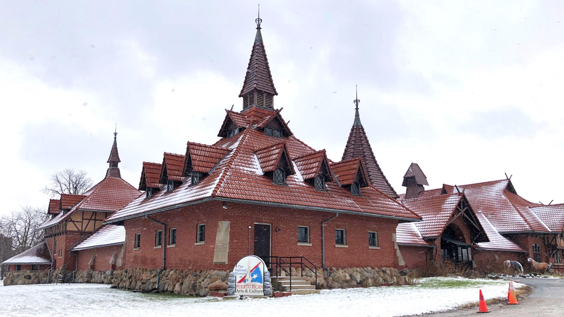 View of the Receptory Building and Stable from its parking lot off of Division Street. In documents prepared for the building's landmark status, it's described as a "visually exuberant structure built in a picturesque architectural style," with unusual features that include a "plethora of steeply-pitched, cross-gable roofs, spires and dormers with diamond-pane windows." (Patty Wetli / WTTW News)