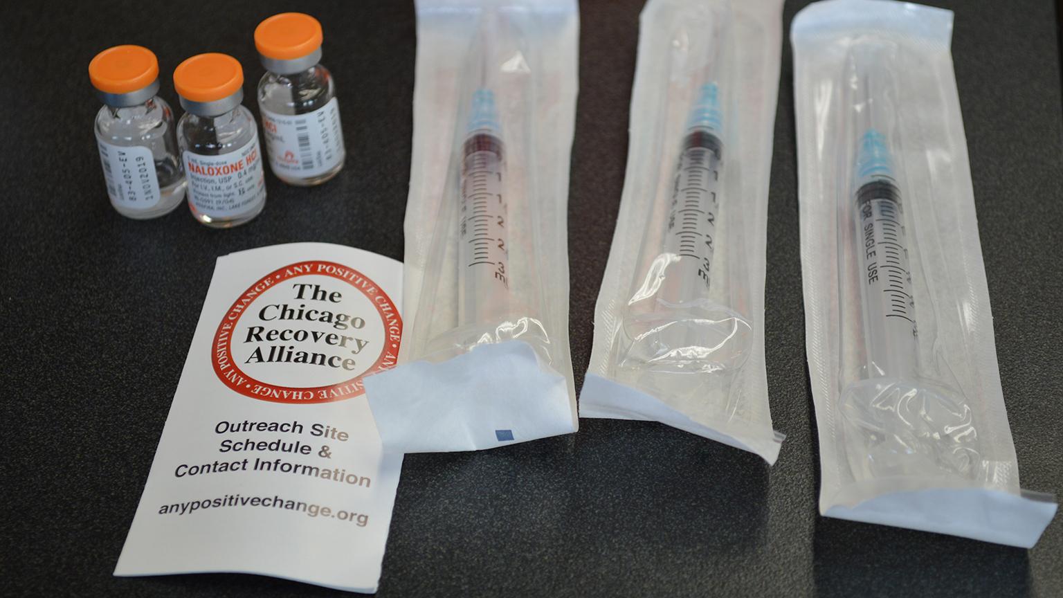 Each naloxone kit contains three vials of naloxone, three syringes and a CRA card to inform people about their services, including its silver van that carries naloxone and other supplies for safer drug use. (Kristen Thometz / Chicago Tonight)