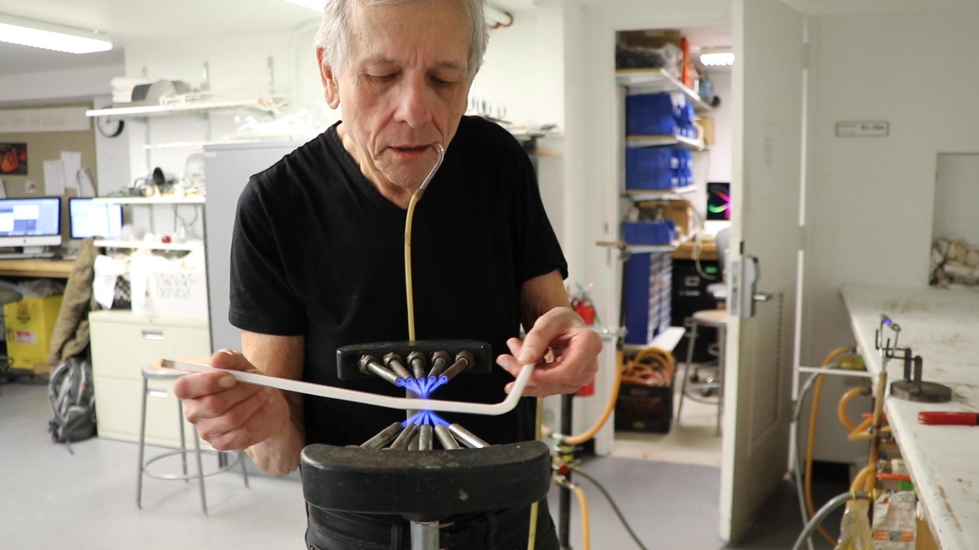 Greg Mowery bends glass at the School of the Art Institute of Chicago’s Light Lab. Mowery has taught neon art at the school for more than 30 years.