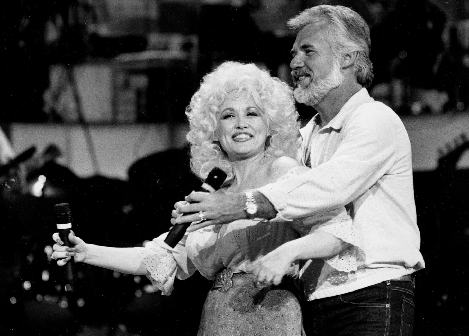 FILE - Dolly Parton, left, and Kenny Rogers rehearse a song for their appearance on the TV show "Live... And in Person" in Los Angeles on Sept. 27, 1983. (AP Photo / Doug Pizac, File)