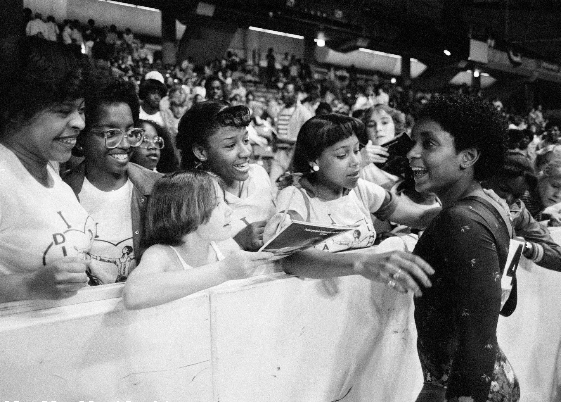 In this June 5, 1983, file photo, Dianne Durham, right, of Gary, Ind., gives autographs after winning the women's title at the McDonald’s U.S.A. Gymnastic Championships at the University of Illinois in Chicago. (AP Photo / Lisa Genesen, File)