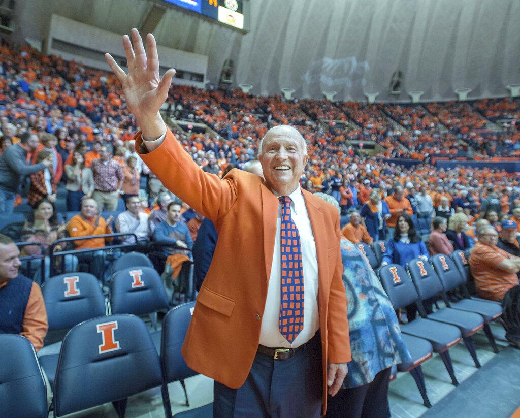 In this Dec. 2, 2015, file photo, former University of Illinois basketball coach Lou Henson acknowledges the crowd while taking his seat courtside during the dedication of the court in his name at the State Farm Center in Champaign, Ill. (AP Photo / Rick Danzl, File)
