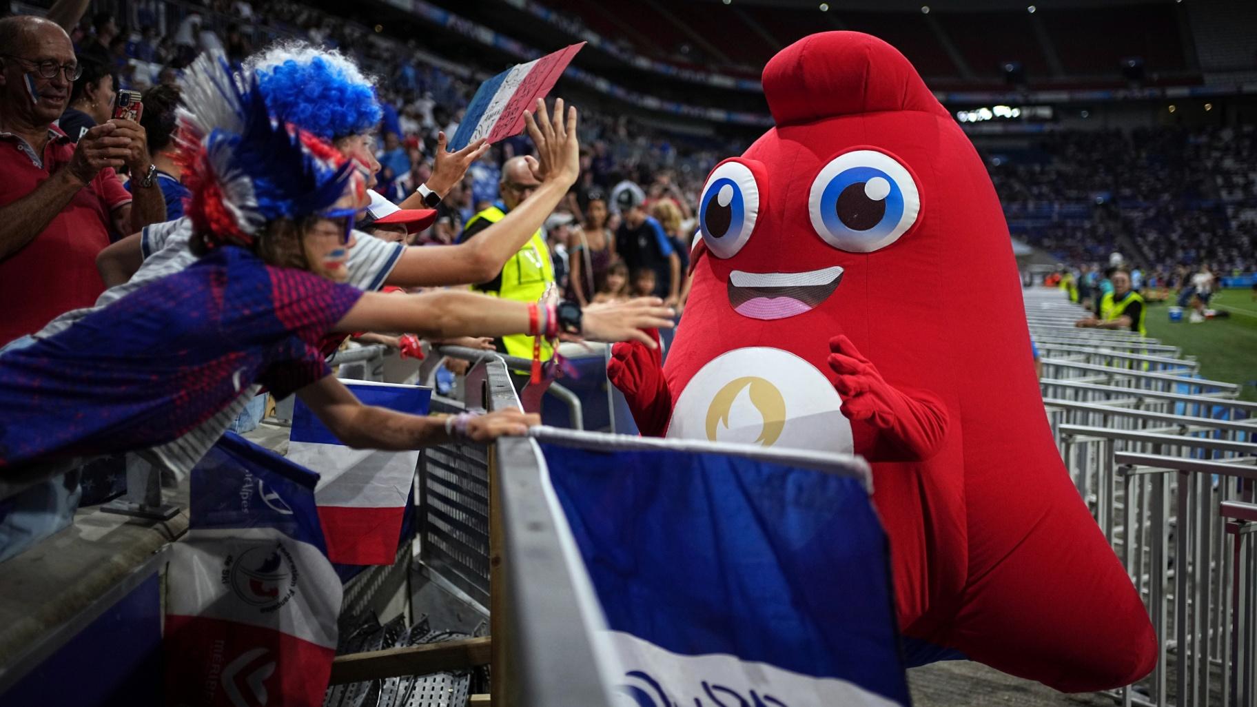 Supporters cheer with Phryge, the Olympic mascot, prior to the women's Group A soccer match between New Zealand and France at the Lyon stadium during the 2024 Summer Olympics, Wednesday, July 31, 2024, in Decines, France. (Laurent Cipriani / AP Photo)