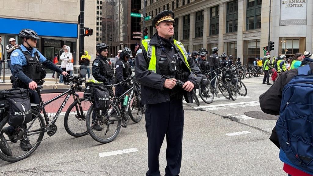 Chicago police officers look on as a May Day march makes its way into downtown Chicago on May 1, 2026. (Eunice Alpasan / WTTW News)