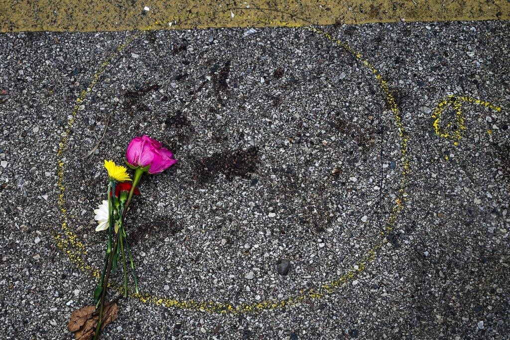 A flower is seen near some police evidence paint around some blood where a protester was shot Wednesday, Aug. 26, 2020, in Kenosha, Wis. (AP Photo / Morry Gash)