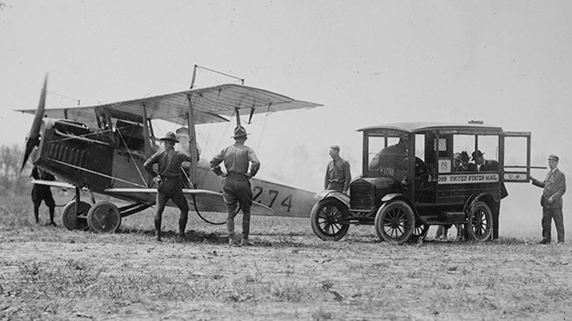 In this photo provided by the National Archives and Records Administration, mail is loaded onto a Curtiss JN-4H &quot;Jenny&quot; biplane, May 15, 1918, at Bustleton Field near Philadelphia, while U.S. Army personnel look on. (National Archives and Records Administration via AP)