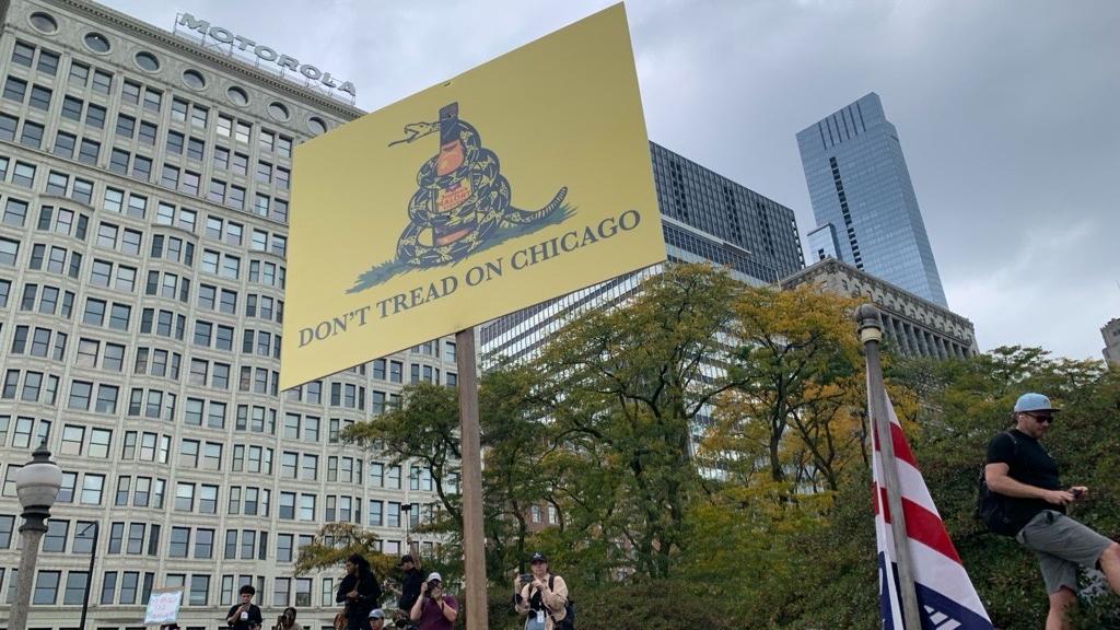 Protesters carry a sign in downtown Chicago during the "No Kings" protest march on Oct. 18, 2025. (Eunice Alpasan / WTTW News)