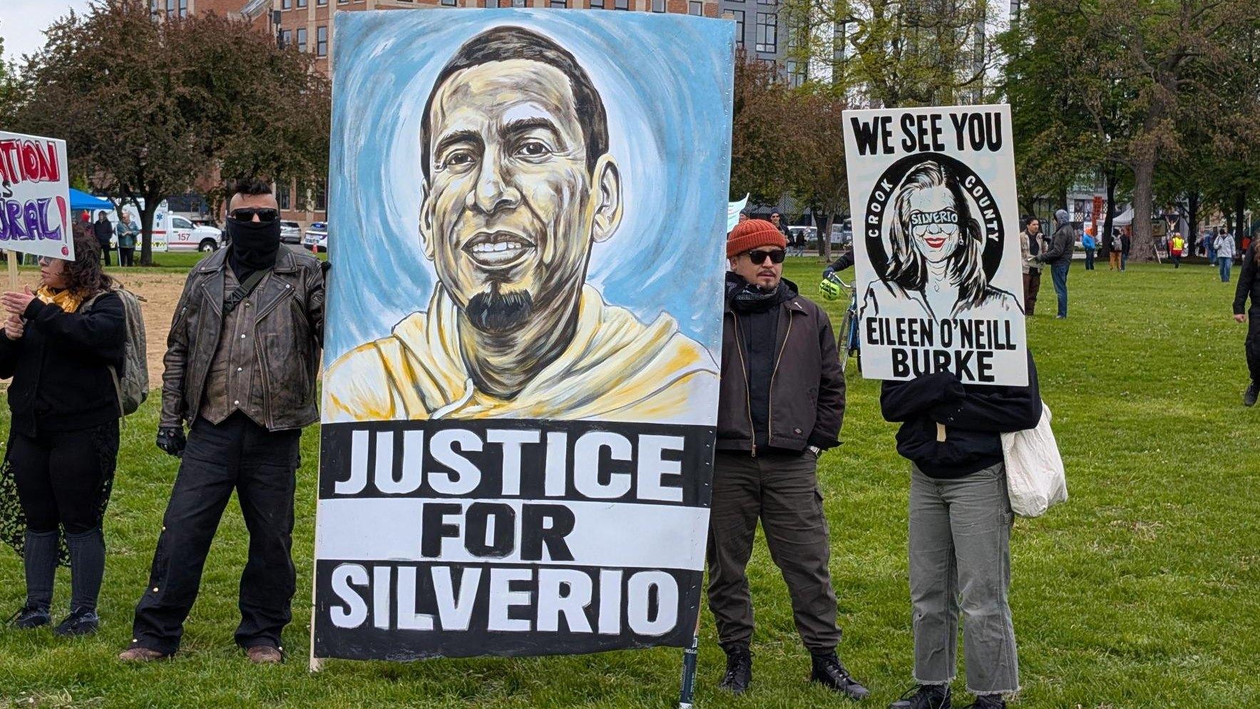 Demonstrators hold a sign with an image of Silverio Villegas González, who was shot and killed by an immigration enforcement officer in Franklin Park in September 2025 during the May 1, 2026, May Day rally. (Matt Masterson / WTTW News) 