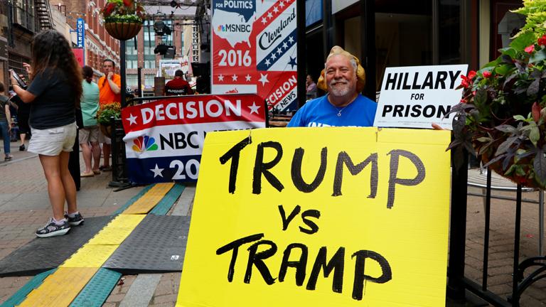 Anti-Hillary Clinton protester Bob Kunst, 74, from Miami Beach, Florida, demonstrates outside of the Quicken Loans Arena. (Evan Garcia)