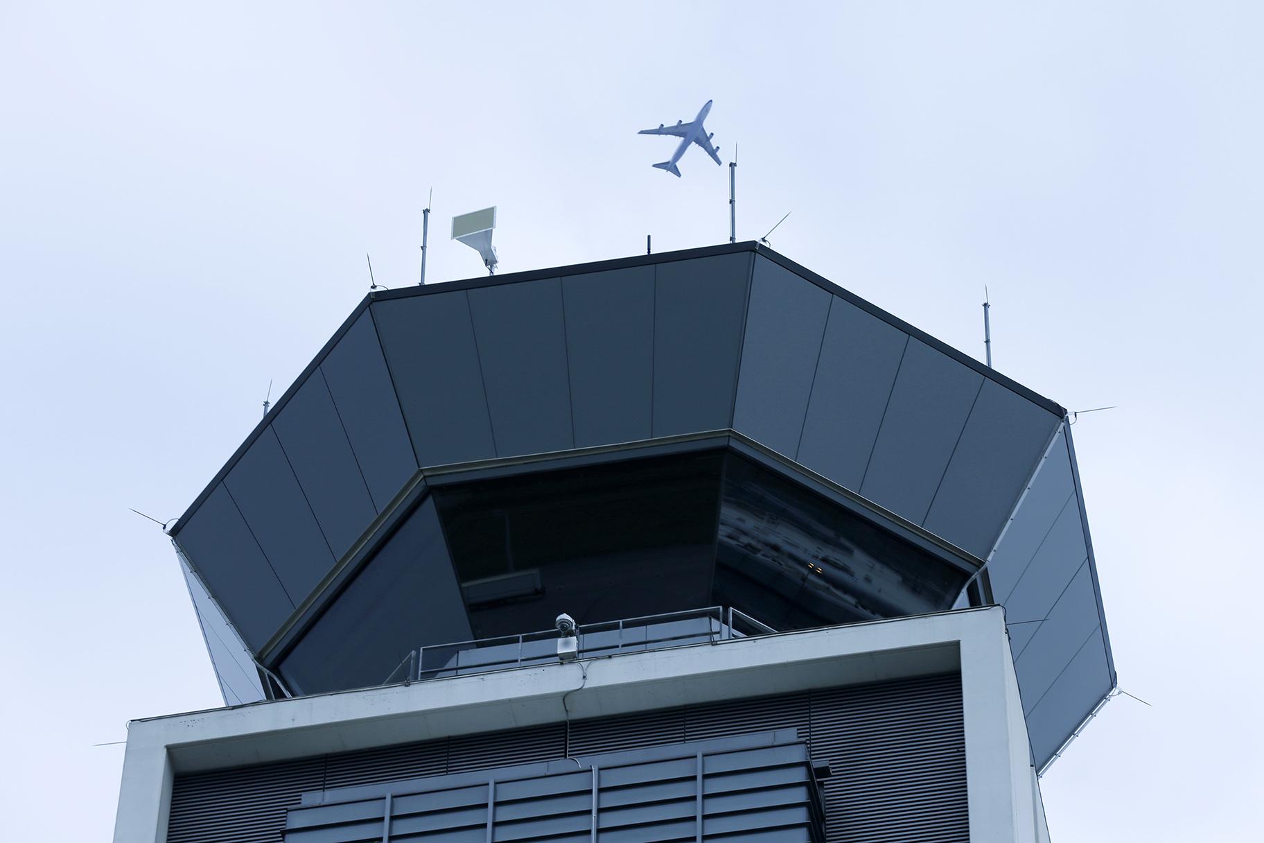 In this Monday, April 22, 2019 file photo, a plane flies over the south air traffic control tower at O'Hare International Airport in Chicago. (AP Photo / Kiichiro Sato, File)