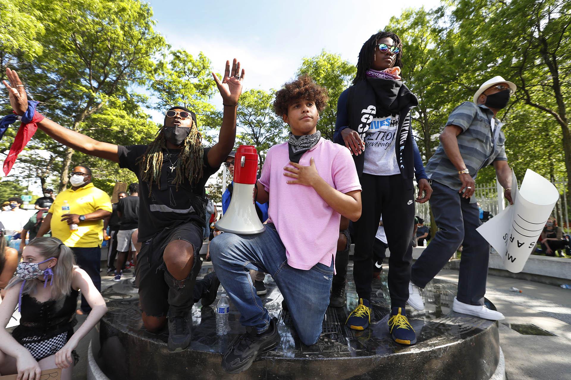 In this June 3, 2020 file photo, Stefan Perez, second from left, addresses a crowd at a rally in Detroit over the death of George Floyd. (AP Photo / Paul Sancya)