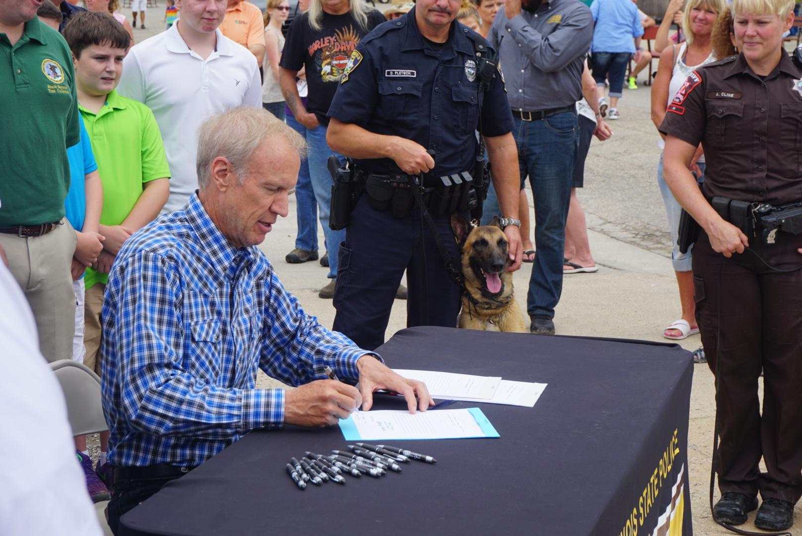 Gov. Bruce Rauner signed a new bill Aug. 15 ensuring retired police dogs can stay with their partner officers. (Illinois Office of the Governor)