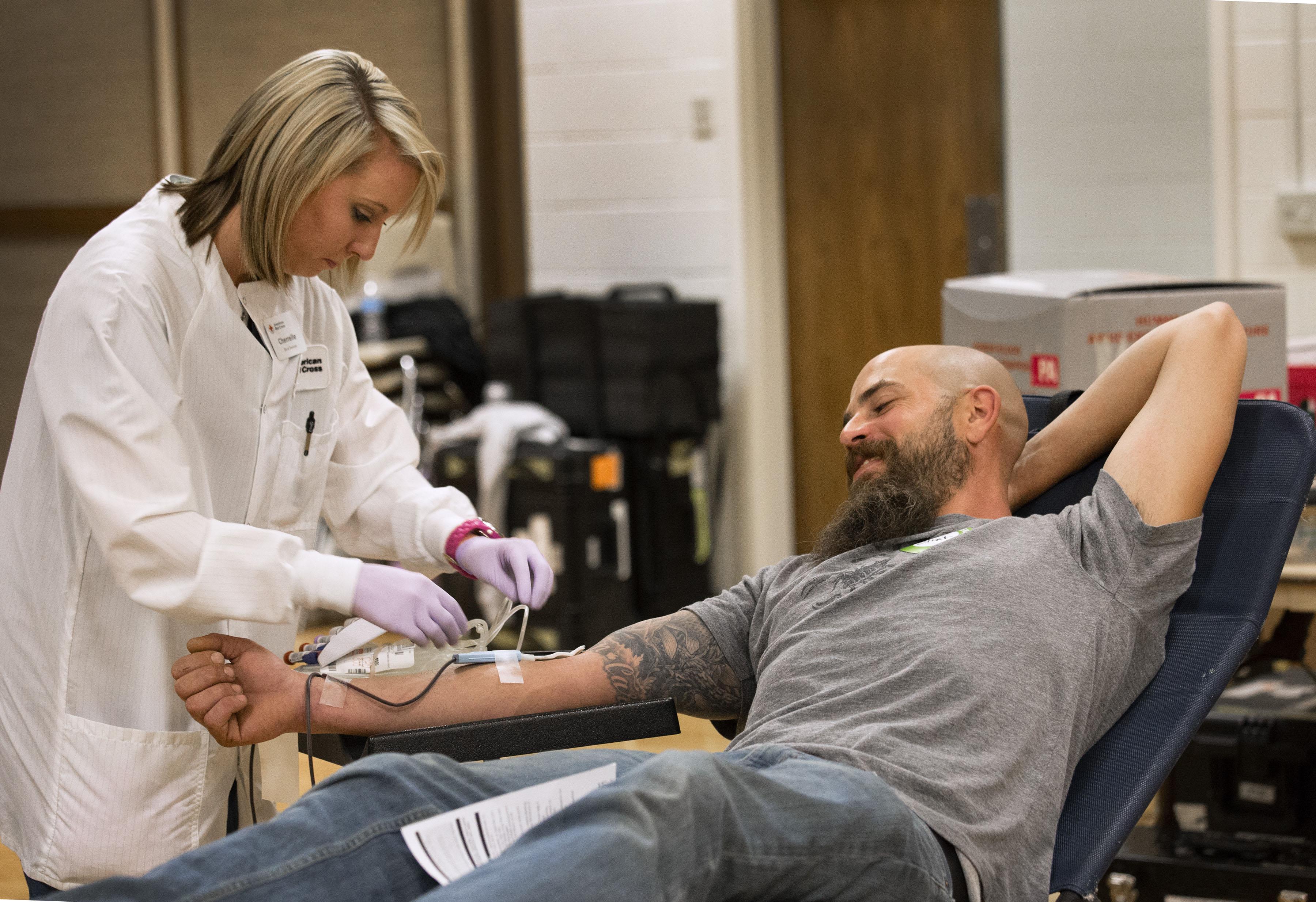 American Red Cross collections staff member Cherrelle Simon collects a blood donation from Clint Kraft, who says that he gives blood because his wife suffers from a rare disease.  (Amanda Romney / American Red Cross) 