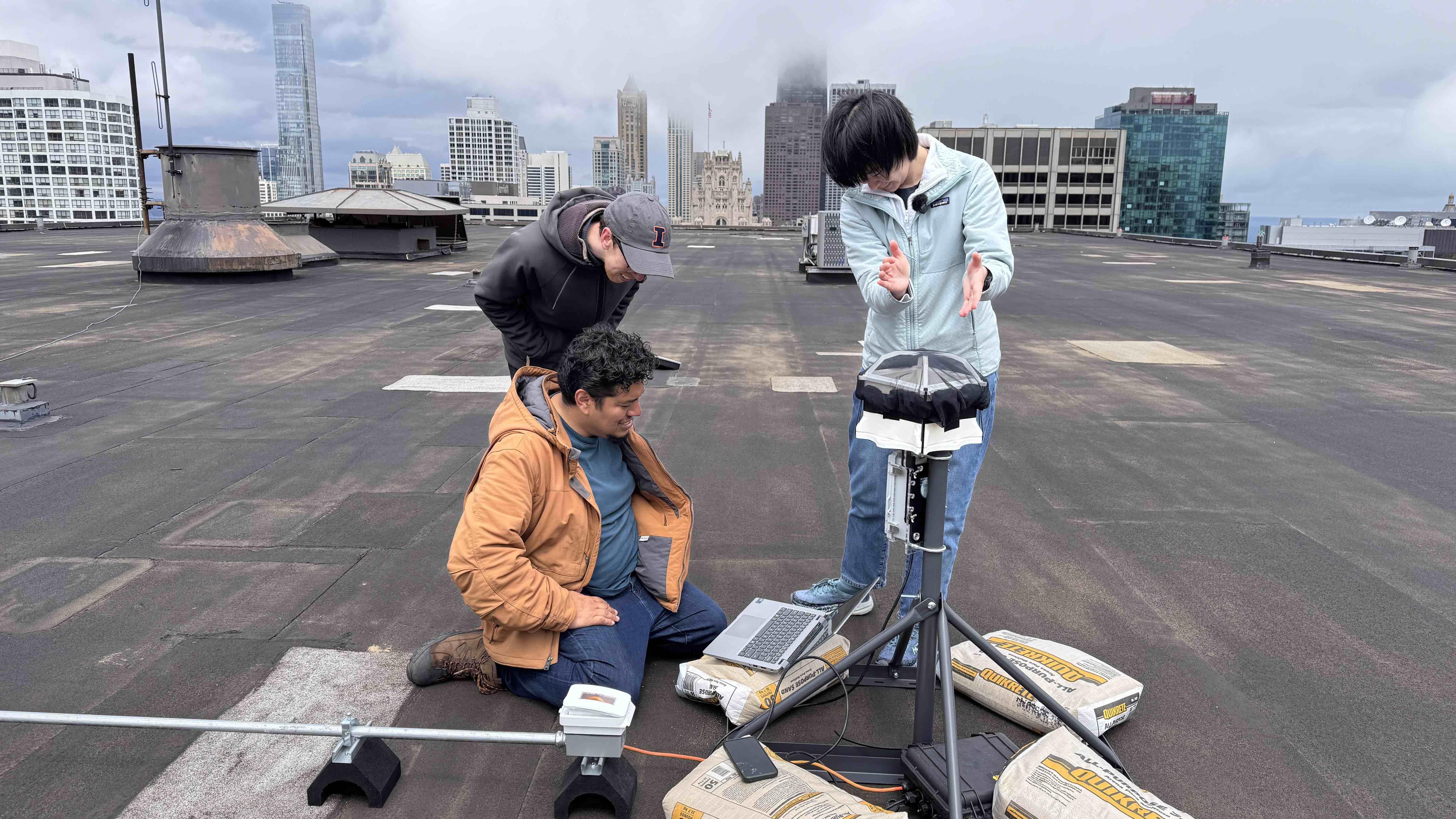 With a few claps of the hand, the team tests the acoustic monitor's microphone and data collection. The device atop Illinois Center will play a role in the upcoming "Flyway City" exhibit at the Chicago Architecture Center. (Patty Wetli / WTTW News)