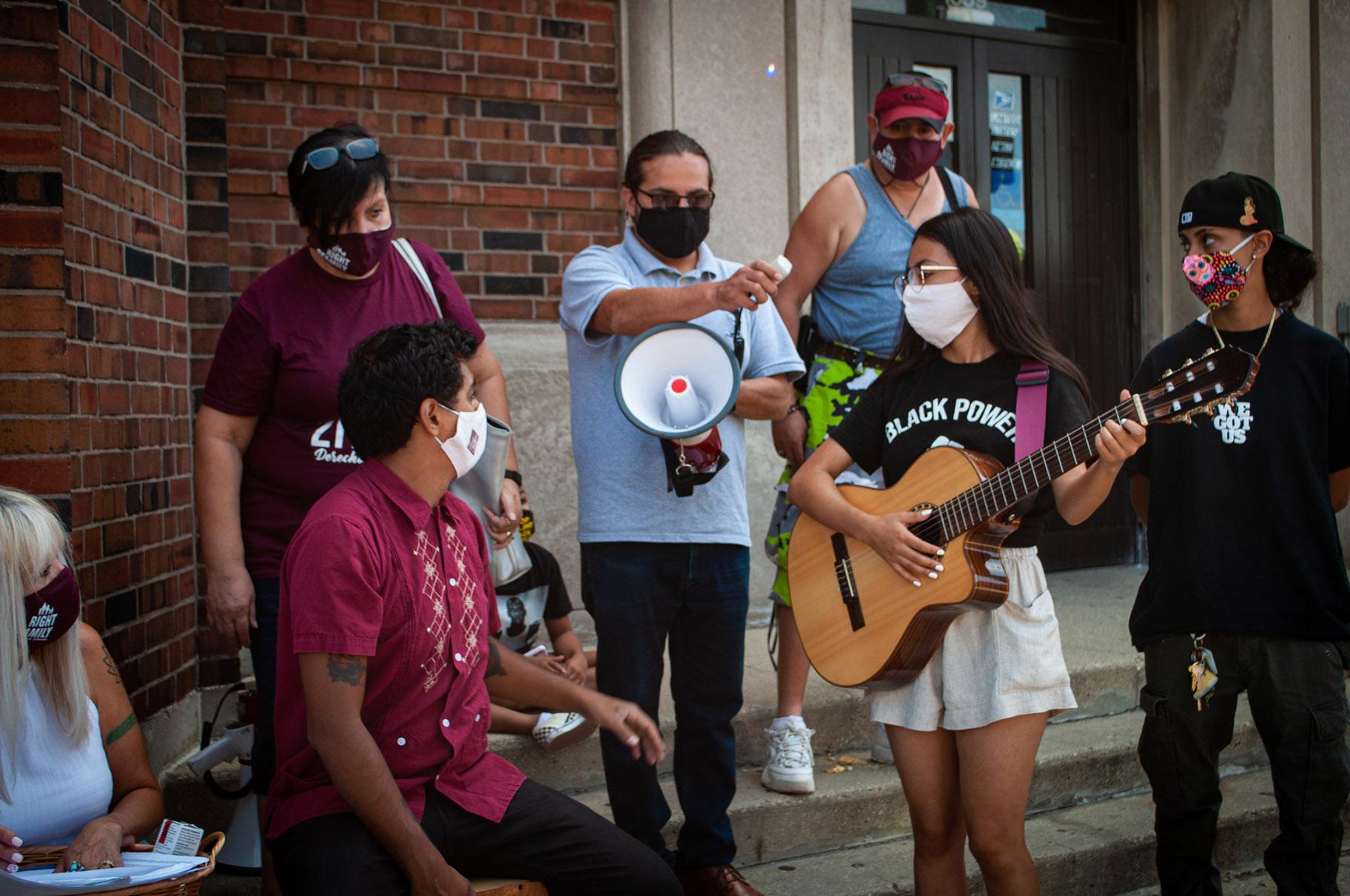 Activists and musicians Rosalba Valdez and Giovany Revelle perform Saturday, Aug. 22, 2020 outside the Pilsen post office. (Grace Del Vecchio / WTTW News)