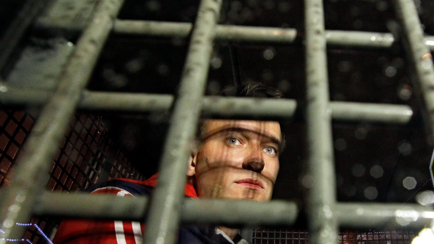 Alexei Navalny is seen behind the bars in the police van after he was detained during protests in Moscow, on May 8, 2012 a day after Putin's inauguration. (AP Photo / Sergey Ponomarev, File)