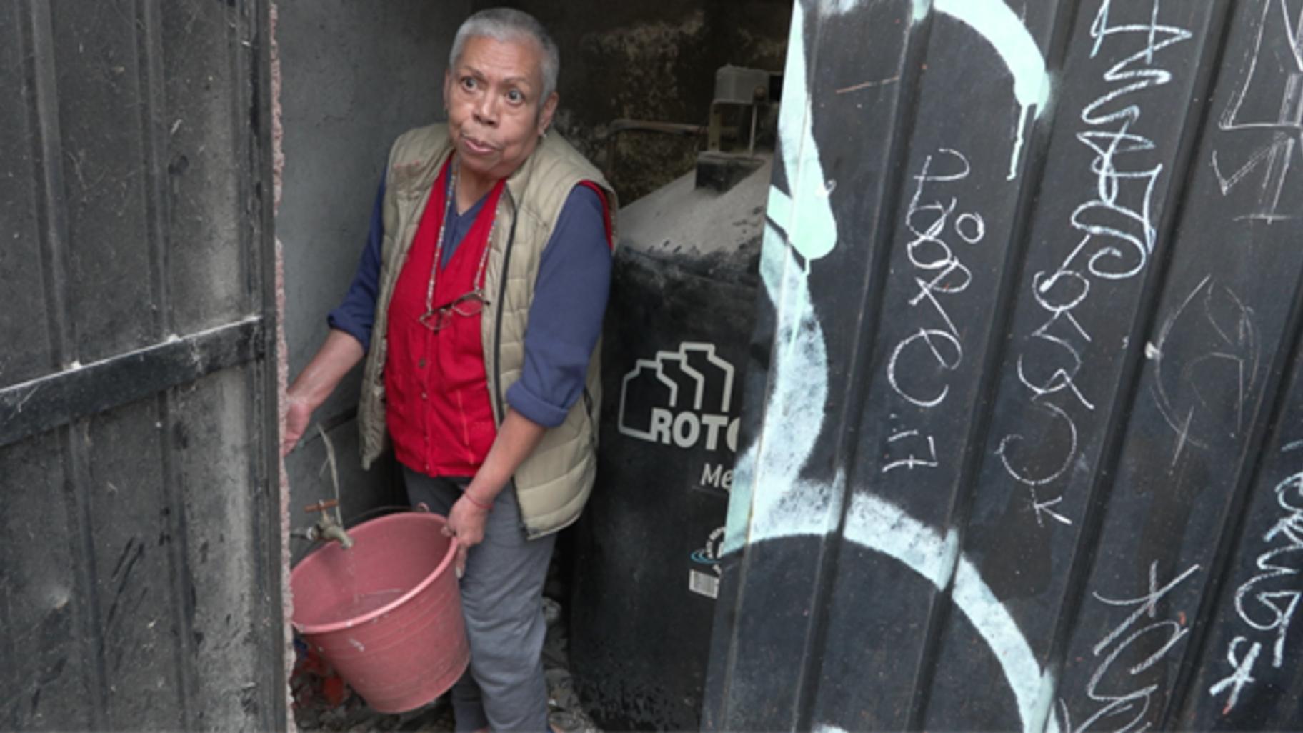 A Santa Ursula resident fills a bucket from a shared tap, as nearby construction at the Estadio Azteca has disrupted water access for many residents surrounding the stadium. (Medill School of Journalism)