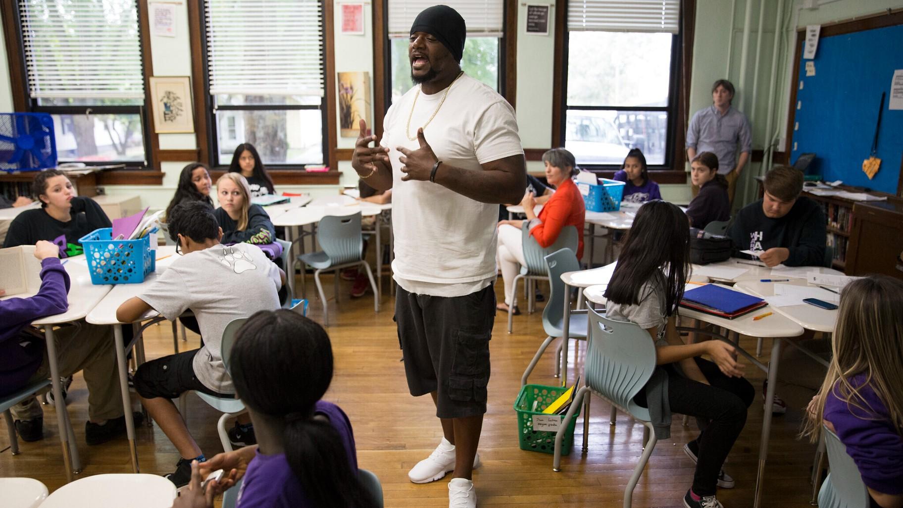 In this image provided by the Des Moines Public Schools, community activist and rap artist Will Keeps works with students at Harding Middle School on Sept. 27, 2017, in Des Moines, Iowa. (Jon Lemons / Des Moines Public Schools via AP)